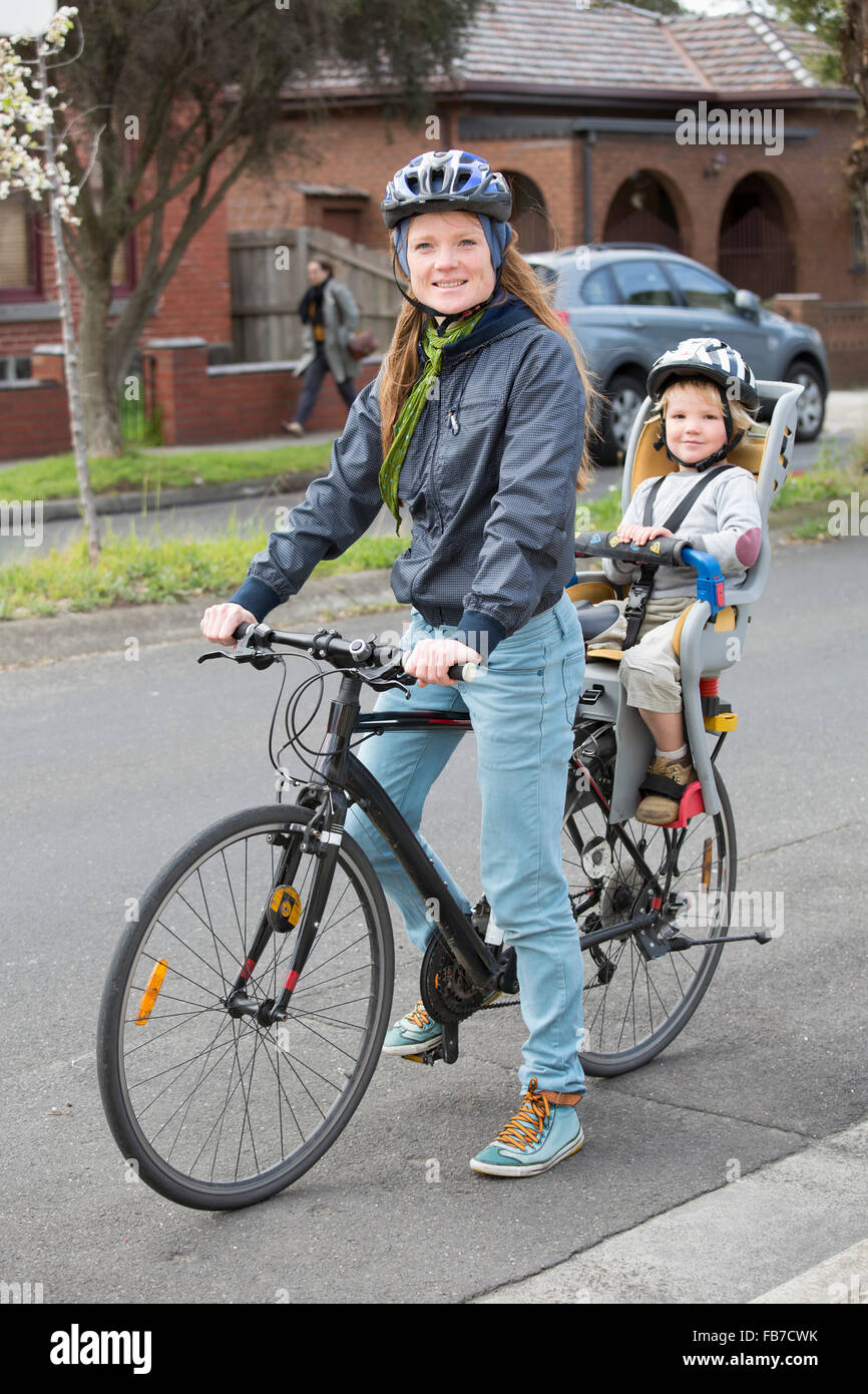 Porträt der Mutter Radfahren während Sohn sitzen auf Rückbank Stockfoto