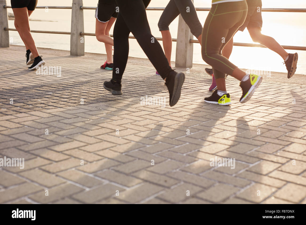 Beine von Läufern, die zusammen zu trainieren, direkt am Meer promenade. Menschen auf der Straße am Meer laufen. Stockfoto