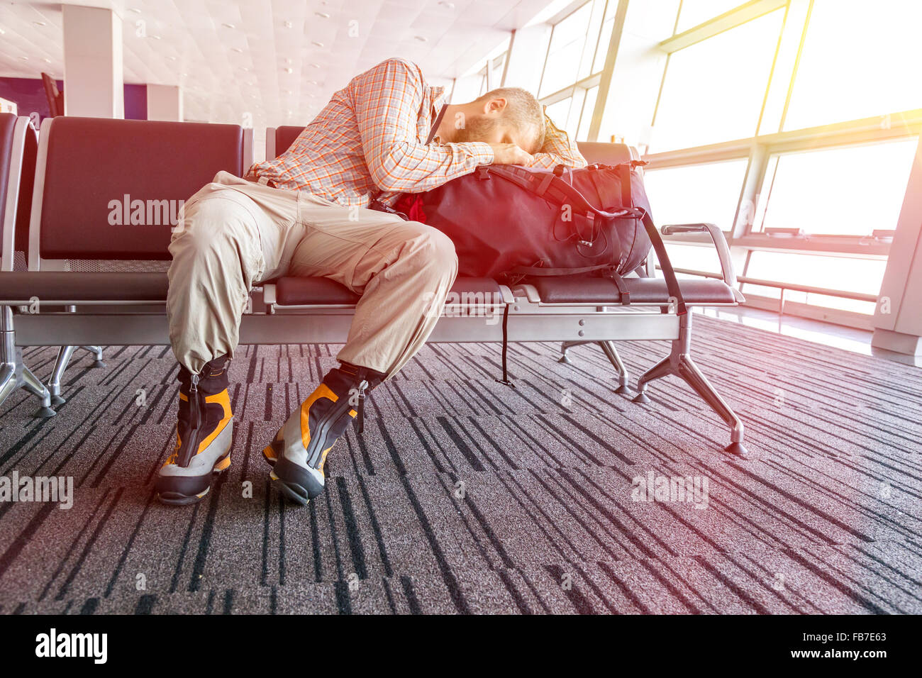 Storniert Flug Mann schläft auf seinem Reisegepäck Stockfoto