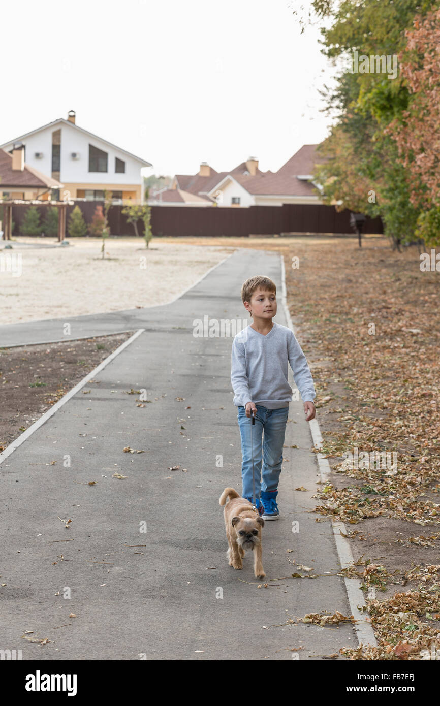 Junge mit Hund auf Wanderweg zu Fuß im Herbst Stockfoto
