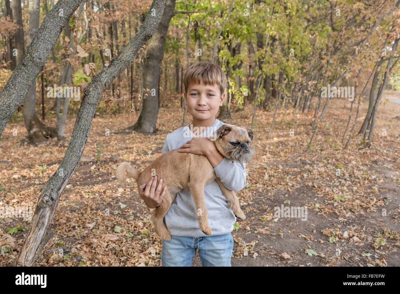 Porträt von netter Junge mit Hund im Wald Stockfoto