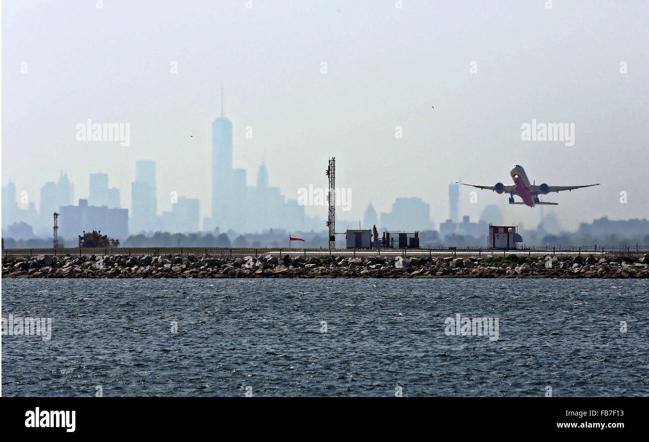 Ein Flugzeug startet vom Flughafen JFK die dunstigen New York Skyline im Hintergrund. Stockfoto