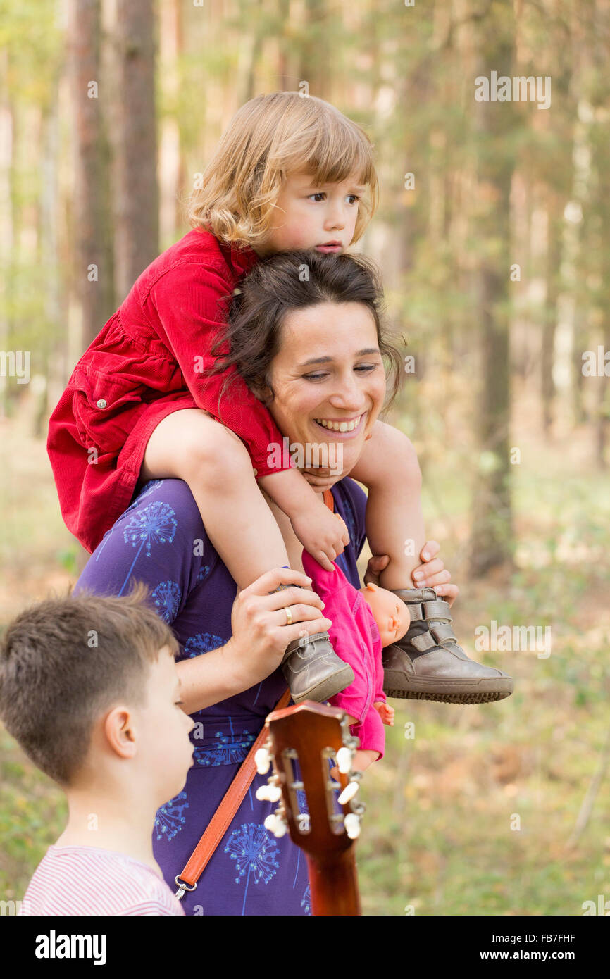 Glückliche Frau, die Tochter im Gespräch mit Sohn im Wald Stockfoto