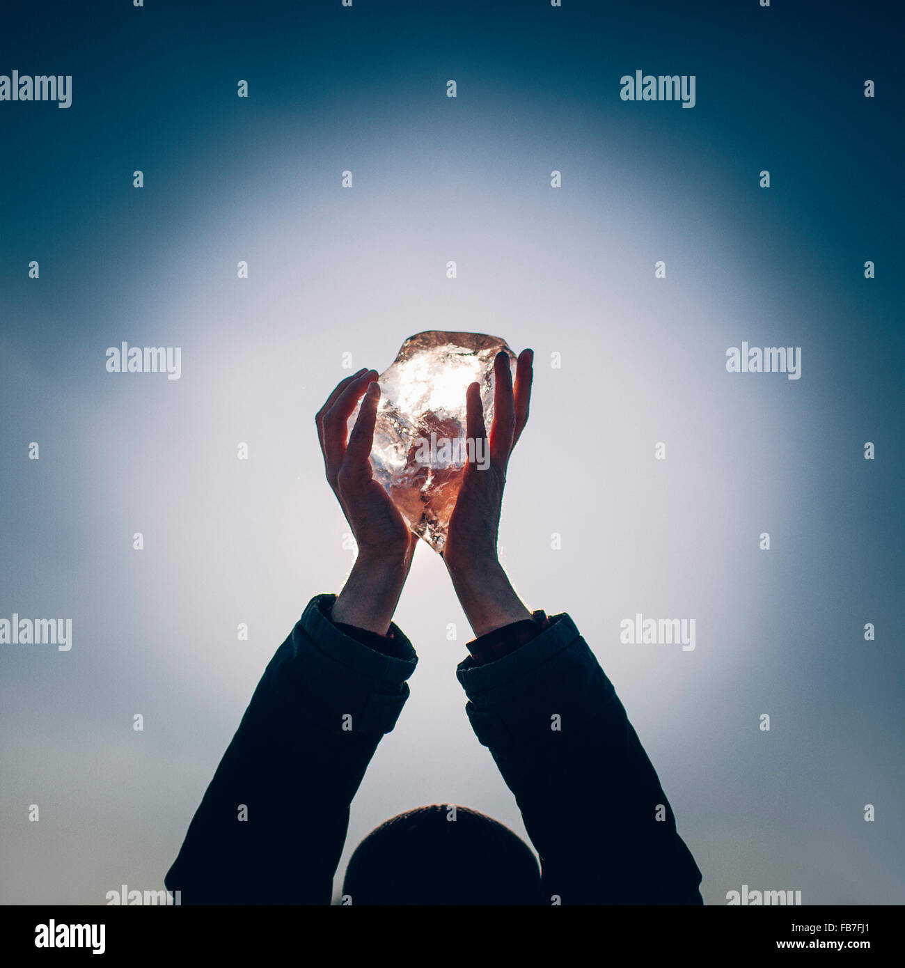 Hände des Mannes halten Eis gegen Himmel in der Abenddämmerung beschnitten Stockfoto