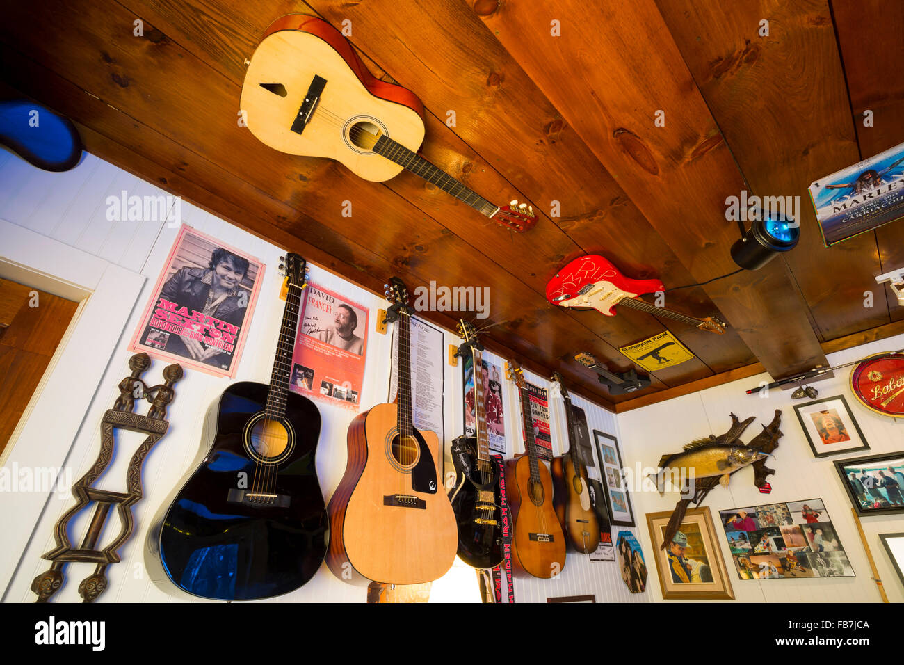 Gitarren und Poster an der Wand im Aufenthaltsraum, Nordamerika; Kanada; Ontario Stockfoto