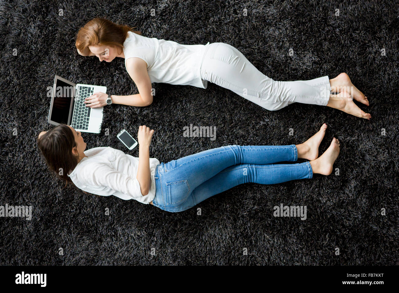 Entspannen Sie sich auf den Teppich junge Frauen Stockfoto