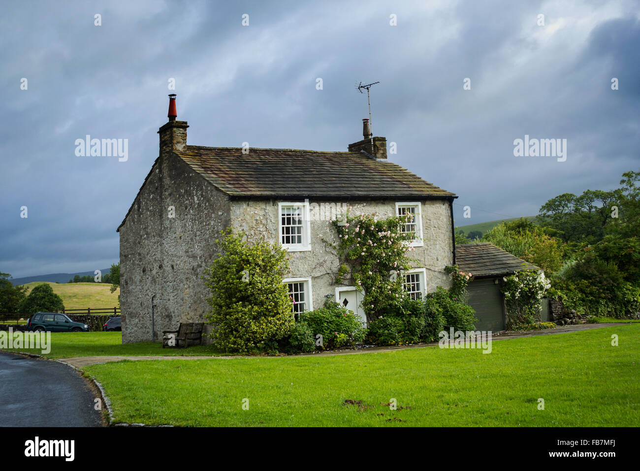 Schöne englische Dorfhaus mit Kletterrosen, Yorkshire, England Stockfoto