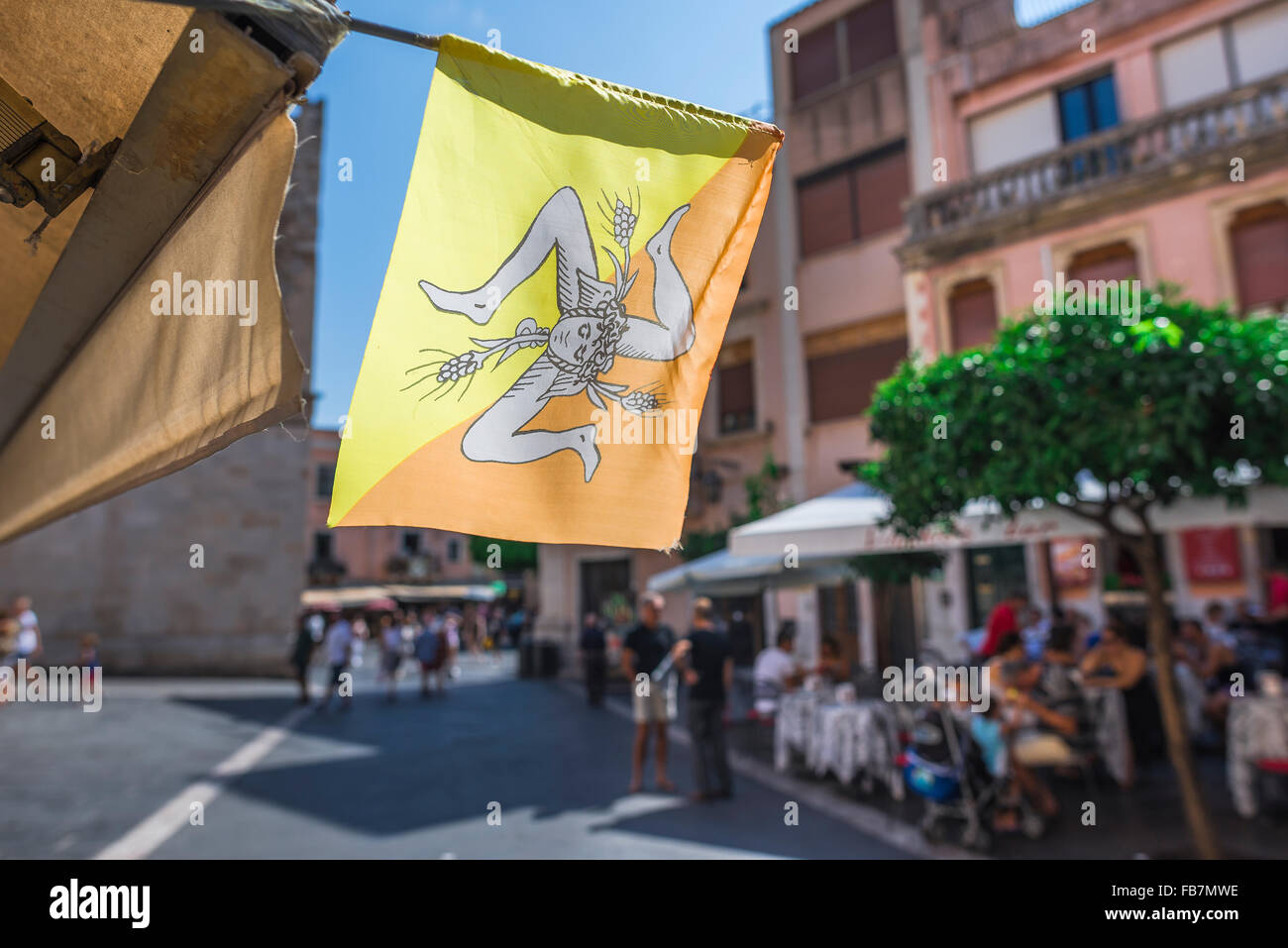 Flagge Sizilien, Blick auf einer beleuchteten Fahne mit dem Emblem von Sizilien - Die trinacria - in eine Straße in der Corso Umberto in Taormina, Sizilien. Stockfoto