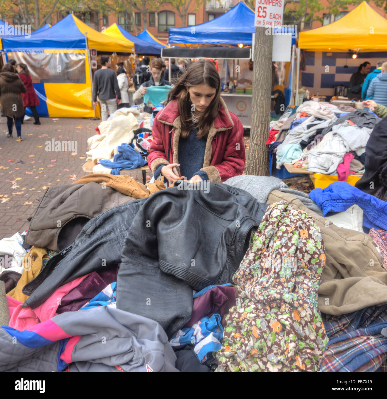junge Frau einkaufen am Markt gebrauchte Kleidung stall Stockfoto