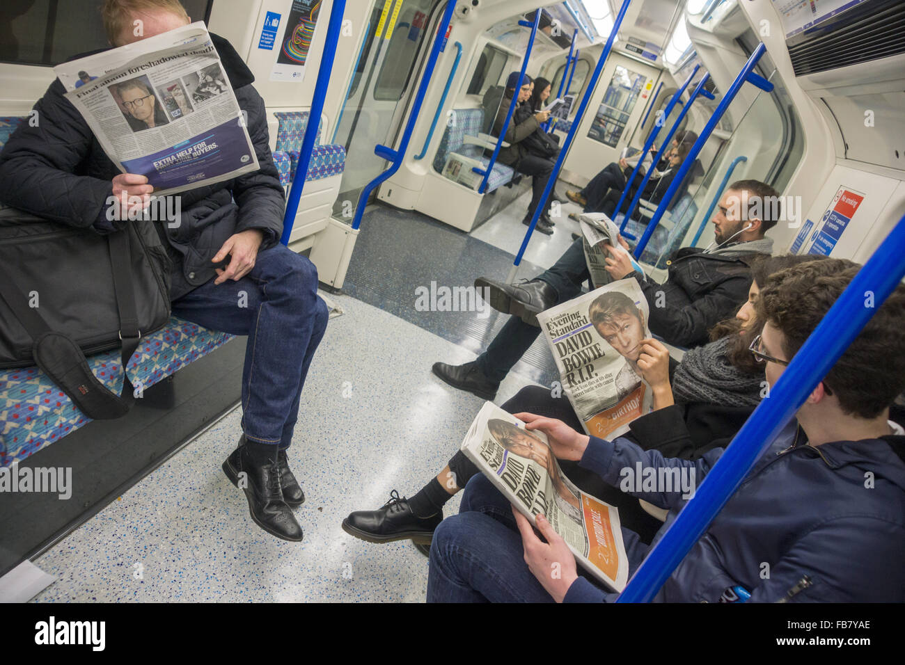 London, UK. 11. Januar 2016. Menschen in der Londoner U-Bahn Lesung des Todes von David Bowie Credit: Marcus Tylor/Alamy Live News Stockfoto