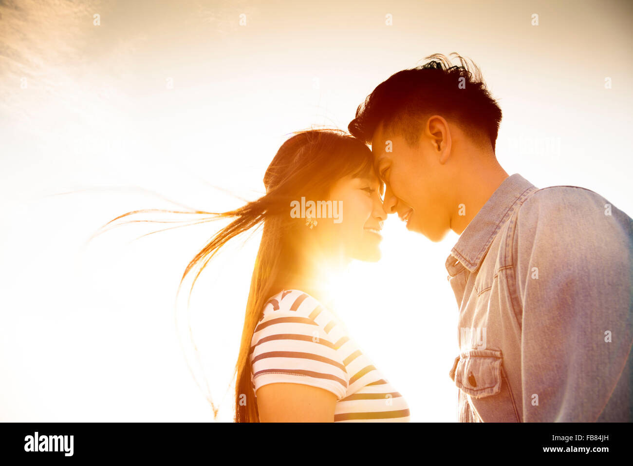 Lächelnde paar in der Liebe mit Sonnenlicht Hintergrund Stockfoto