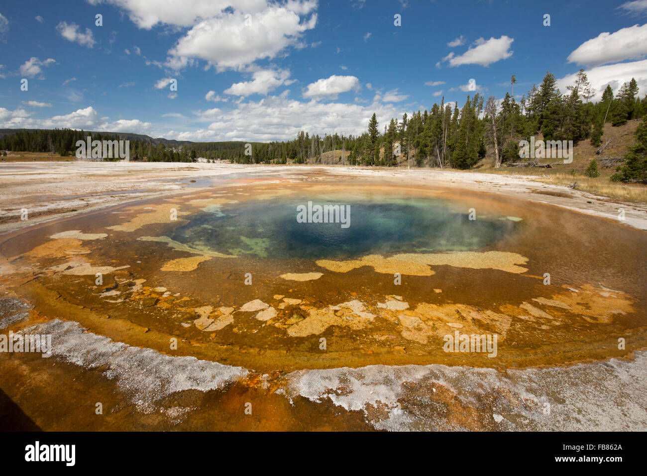 Bunten orangenen und blauen Wasser in chromatischer Pool Hot Springs unter einem sonnigen blauen Himmel in der Upper Geyser Basin von Yellowstone. Stockfoto