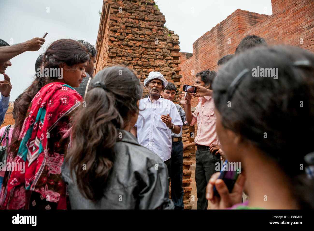 Universitätsstudenten erhalten Erläuterungen von einem Reiseleiter, während sie den alten buddhistischen Universitätskomplex von Nalanda in Nalanda, Bihar, Indien besuchen. Stockfoto