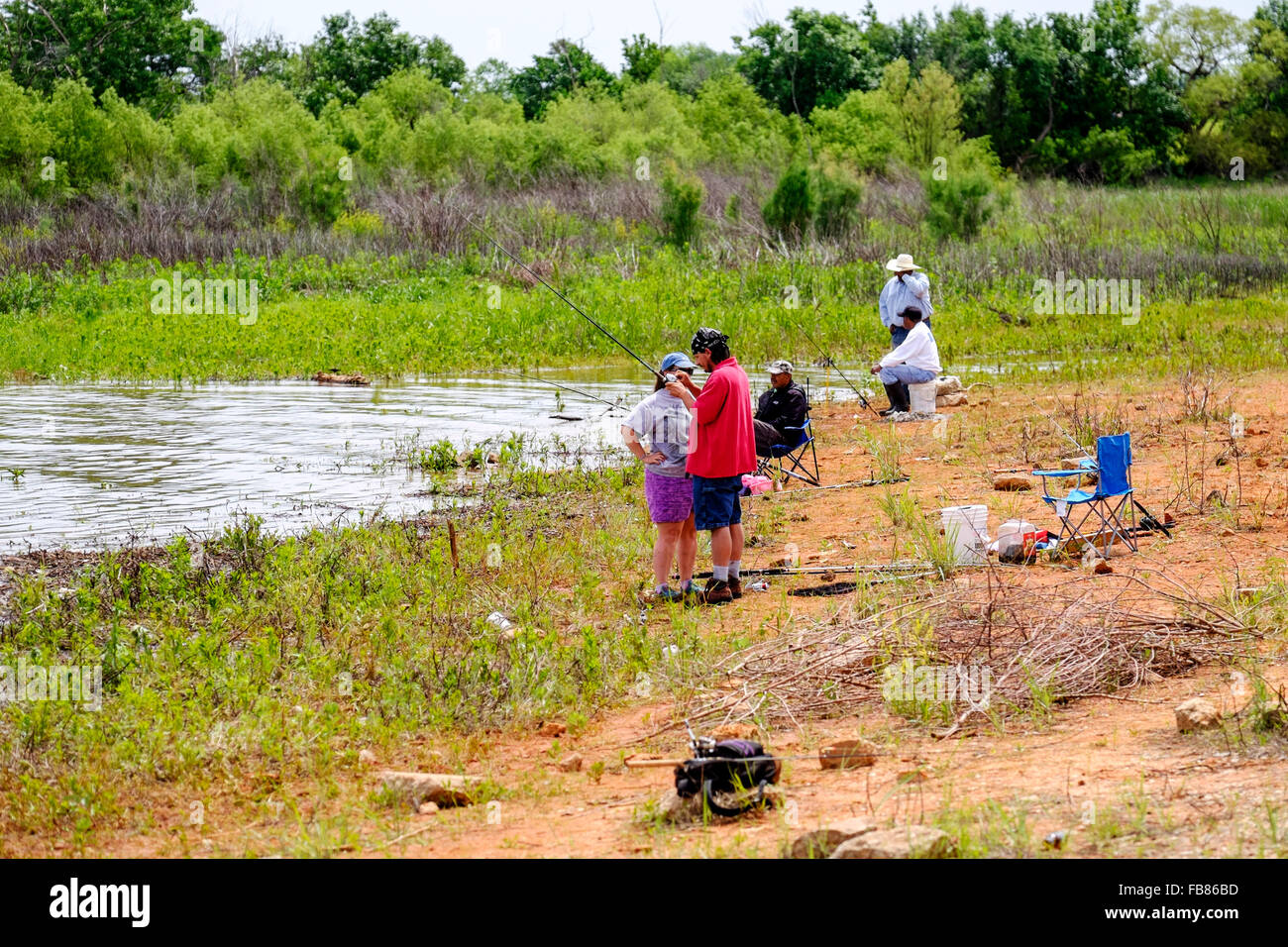 Nach einem Frühlingsregen fischen die Menschen in den aufsteigenden Gewässern des Hefner Lake in Oklahoma City, Oklahoma, USA. Stockfoto