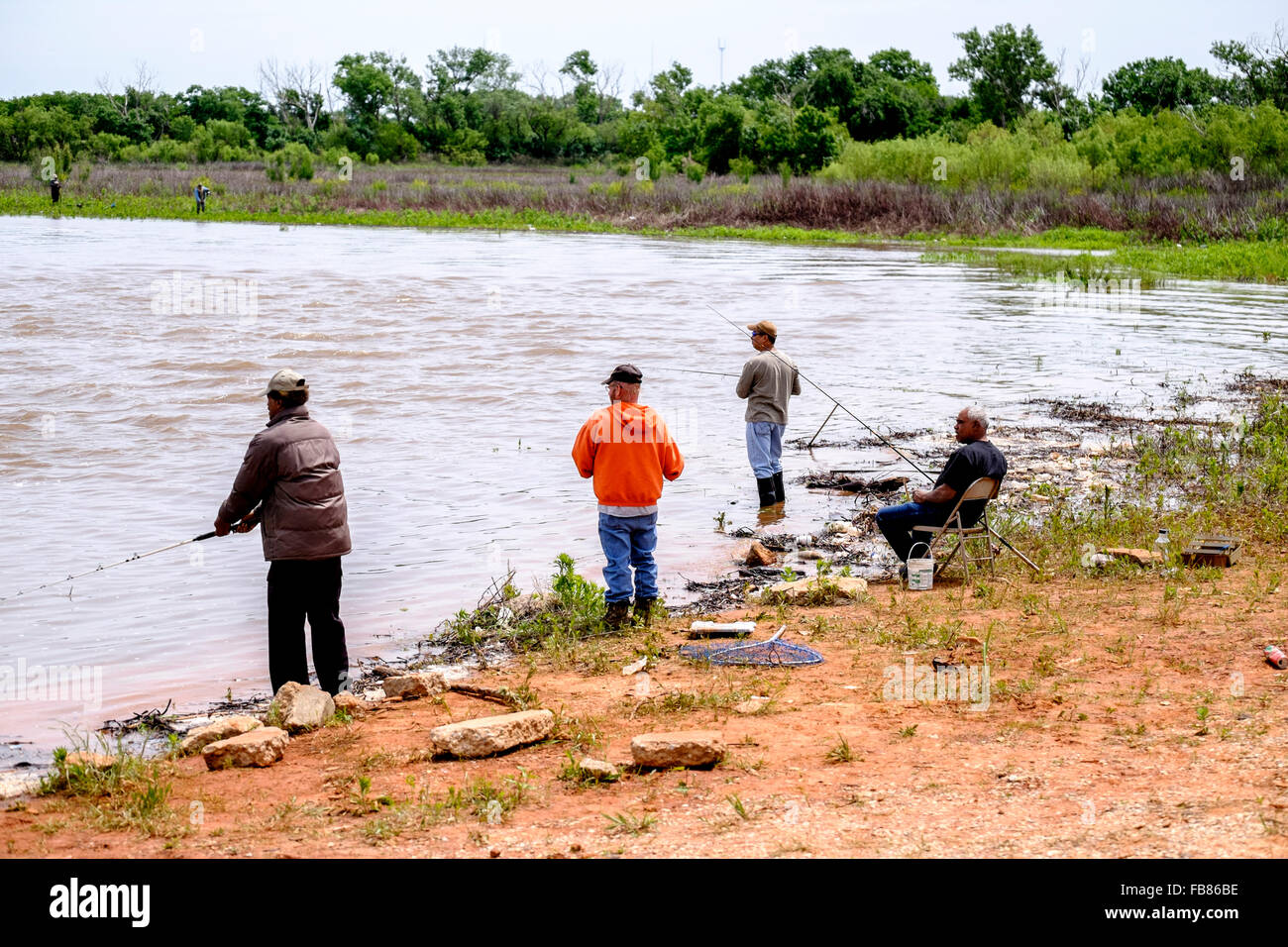 Menschen Fisch in den Fluten des Sees Hefner in Oklahoma City nach einem Frühlingsregen. Oklahoma, USA. Stockfoto