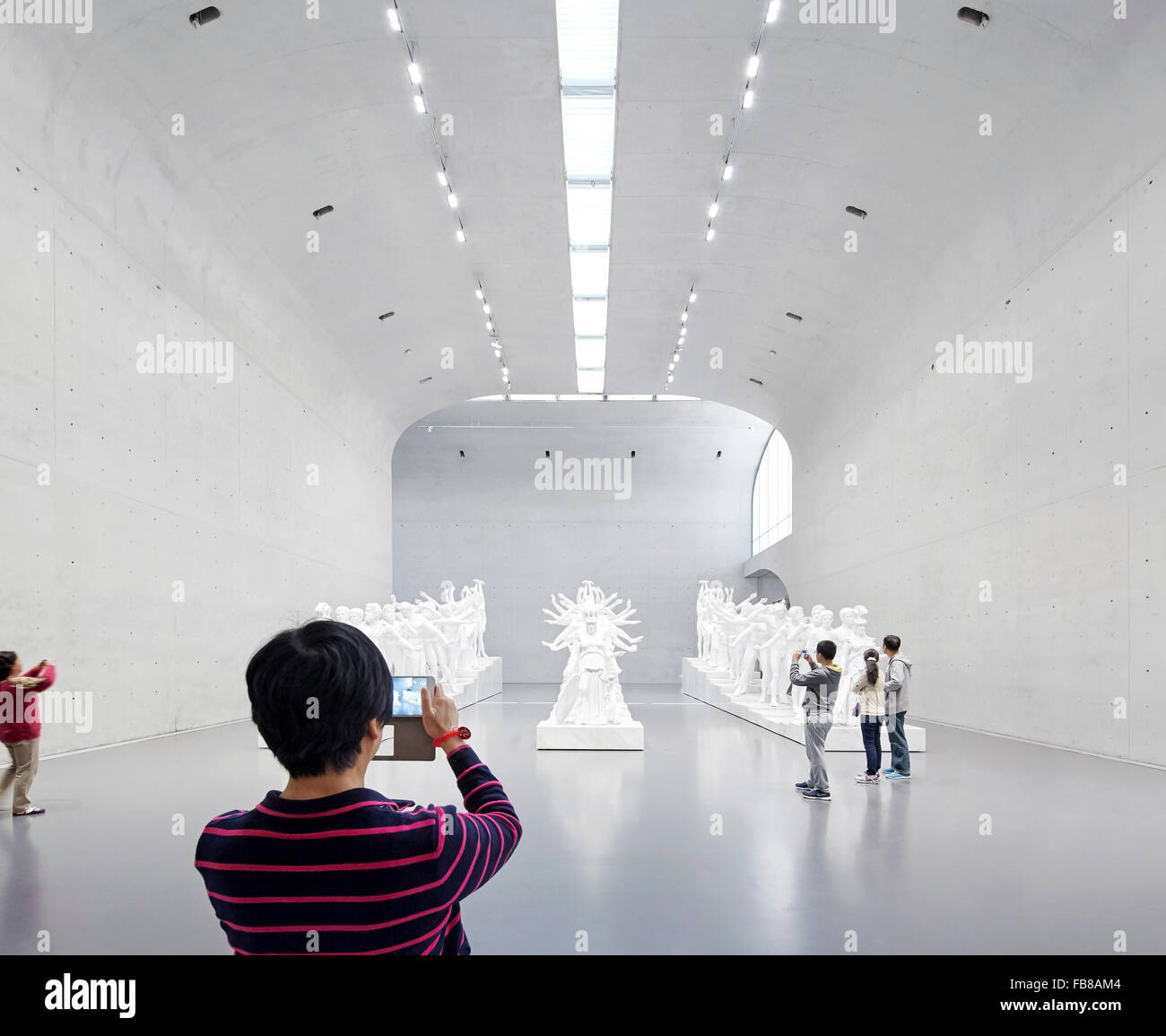 Ausstellungshalle mit Besuchern. Lange Museum West Bund, Shanghai, China. Architekt: Atelier Deshaus, 2015. Stockfoto