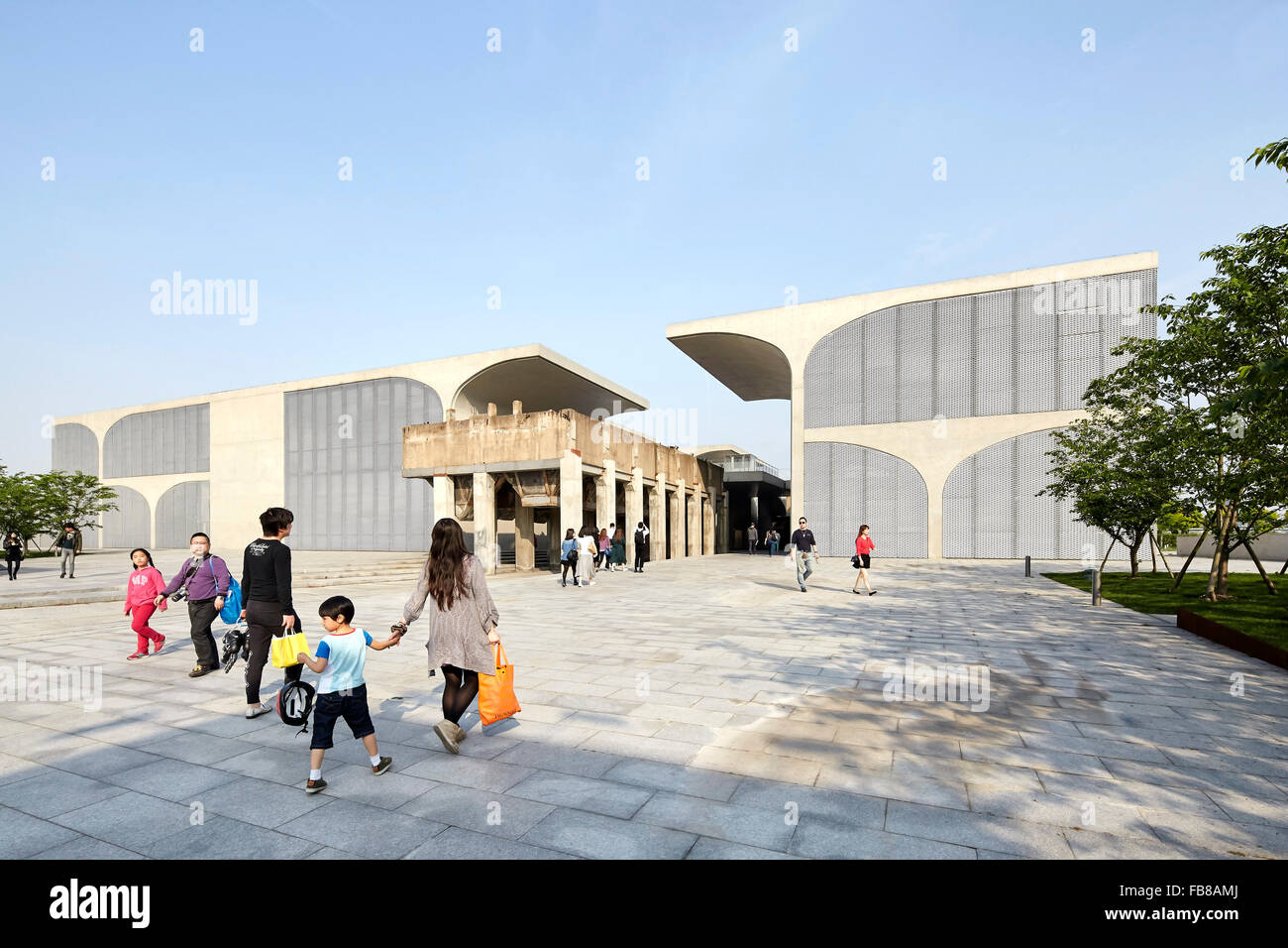 Gesamtansicht der Museumsplatz mit Fußgängern. Lange Museum West Bund, Shanghai, China. Architekt: Atelier Deshaus, 2015. Stockfoto