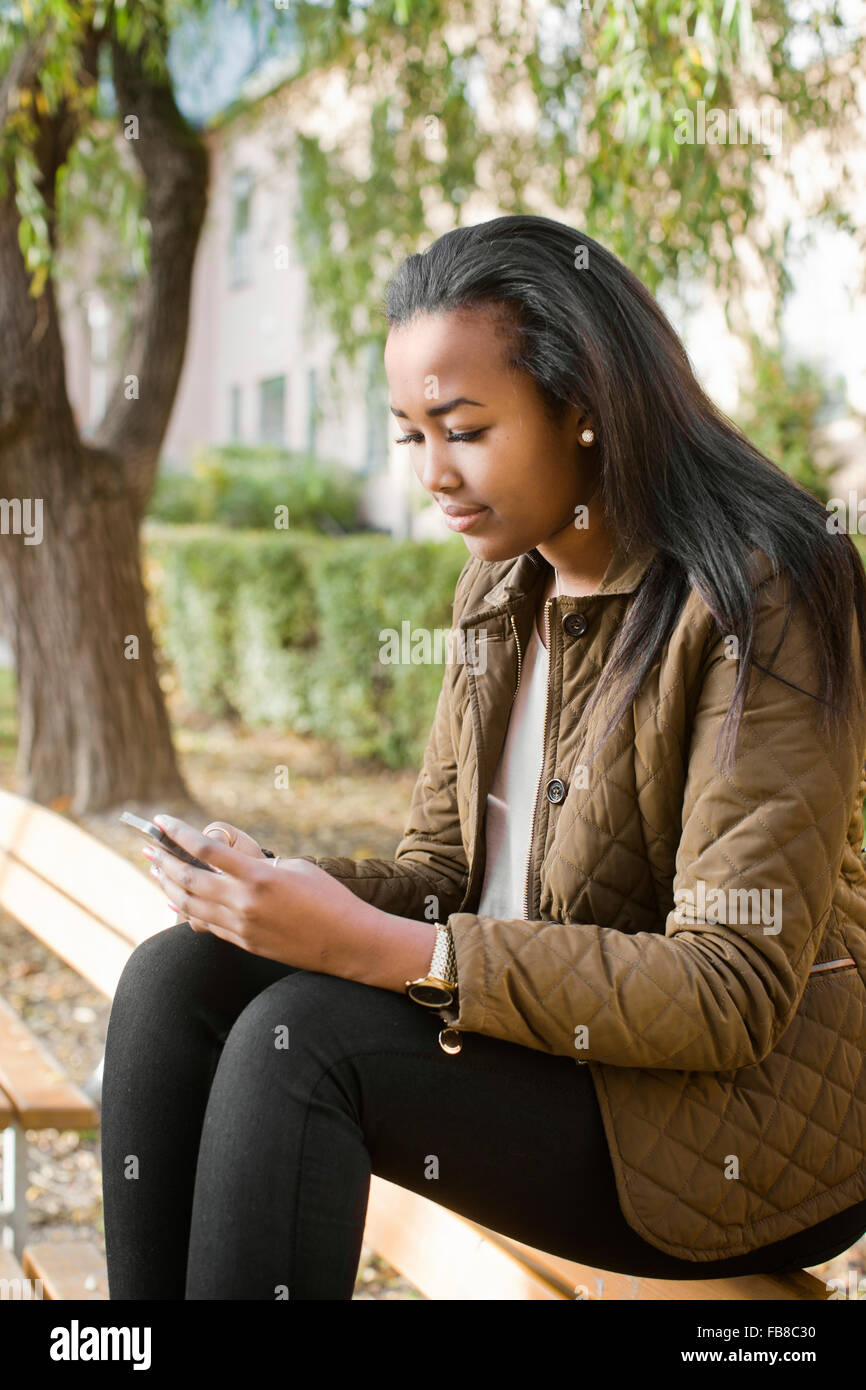 Schweden, Sodermanland, Strangnas, Teenage Girl (16-17) SMS im park Stockfoto