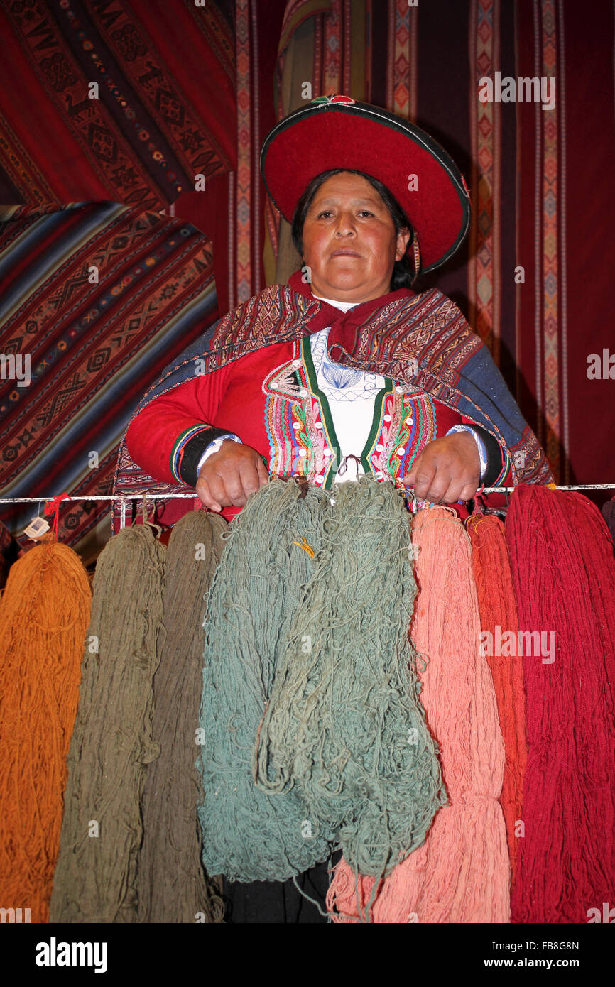 Traditionell gekleidete peruanische Frau hält natürlich gefärbten Alpaka und Lama Wolle Garn Stockfoto