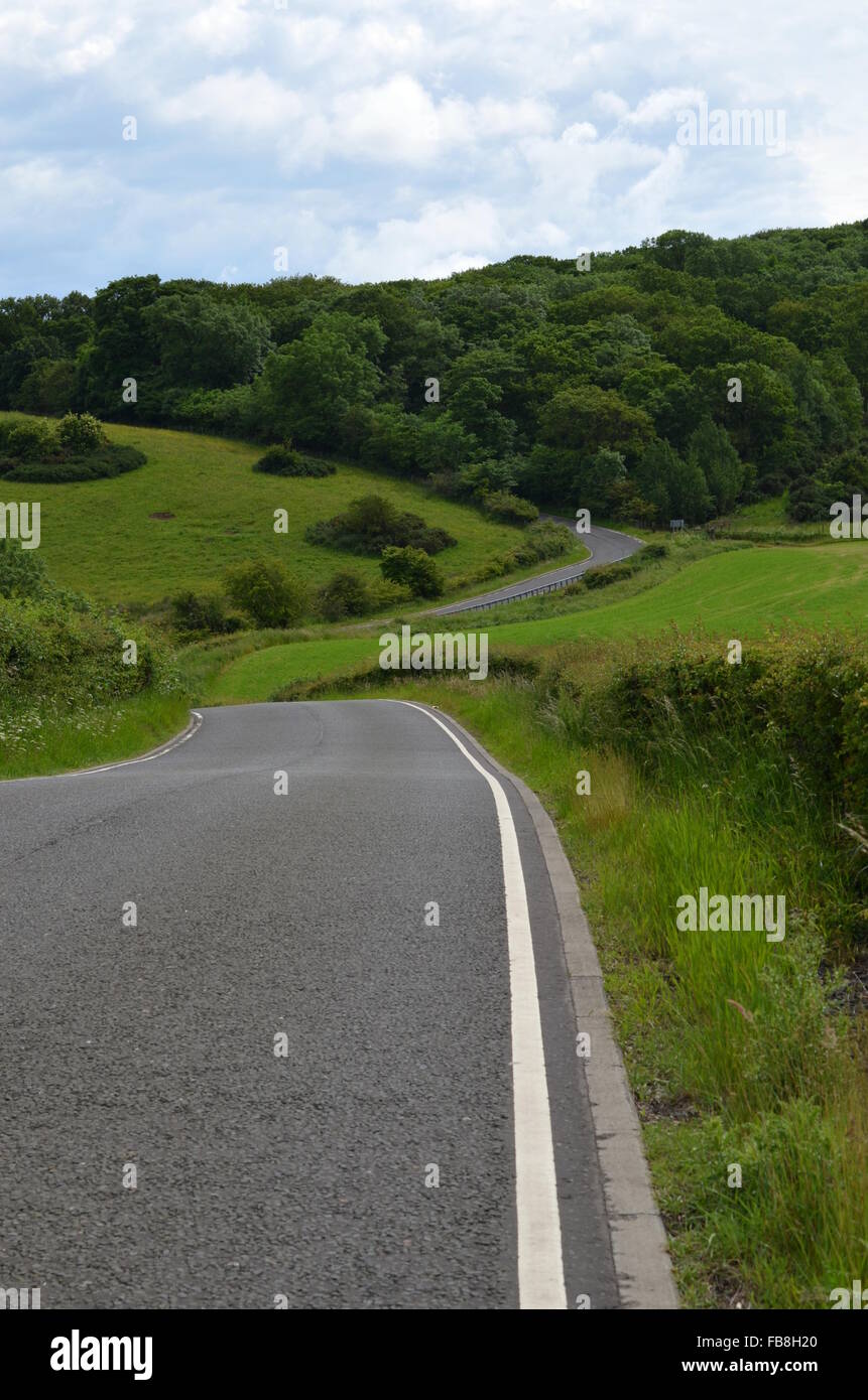 Straße biegen in Richtung grüne Hügel, West Lothian, Schottland Stockfoto