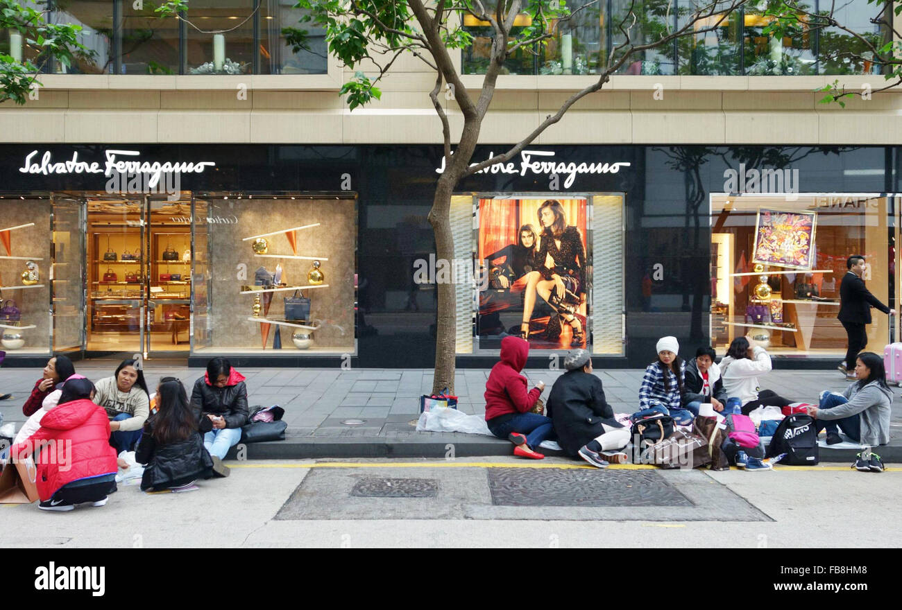 Hong Kong, China. 20. Dezember 2015. Philippinische Hausangestellte Picknick inmitten von Banken und Mode speichert in den teuren wichtigsten Geschäftsviertel in der Nähe von Statue Square in Hong Kong, China, 20. Dezember 2015. Jeden Sonntag wird ein Treffpunkt für Tausende von philippinischen Hausangestellten Stadtteil verwandelt. Das Arbeitnehmer-Picknick auf dem Boden, Karten spielen, tanzen, halten Schönheitswettbewerbe oder ruhen neben Banken und Mode Poster. Foto: ANNE-SOPHIE GALLI/Dpa/Alamy Live News Stockfoto