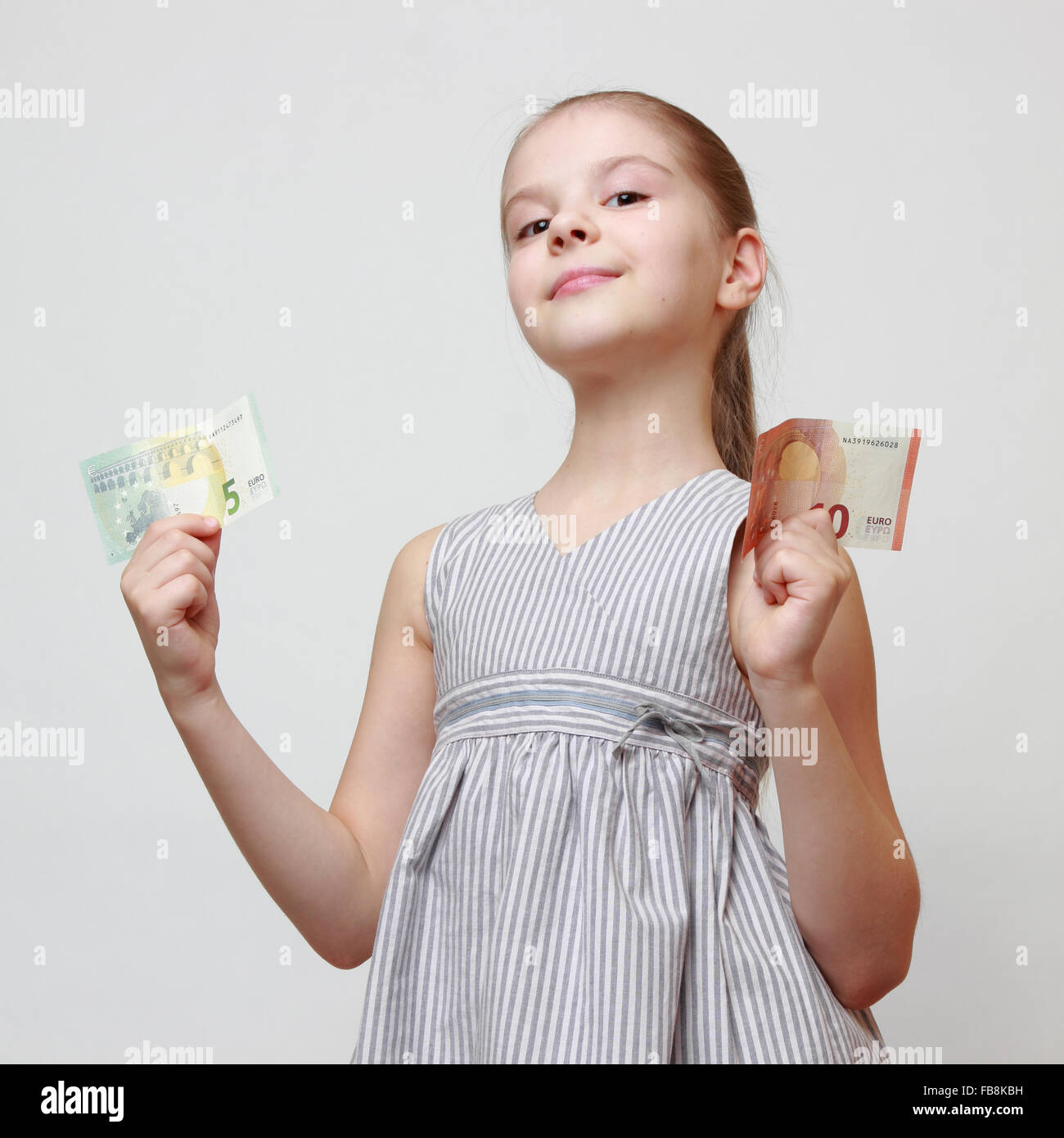 Wunderschönes kleines Mädchen hält Euro-Bargeld-Banknoten Stockfoto