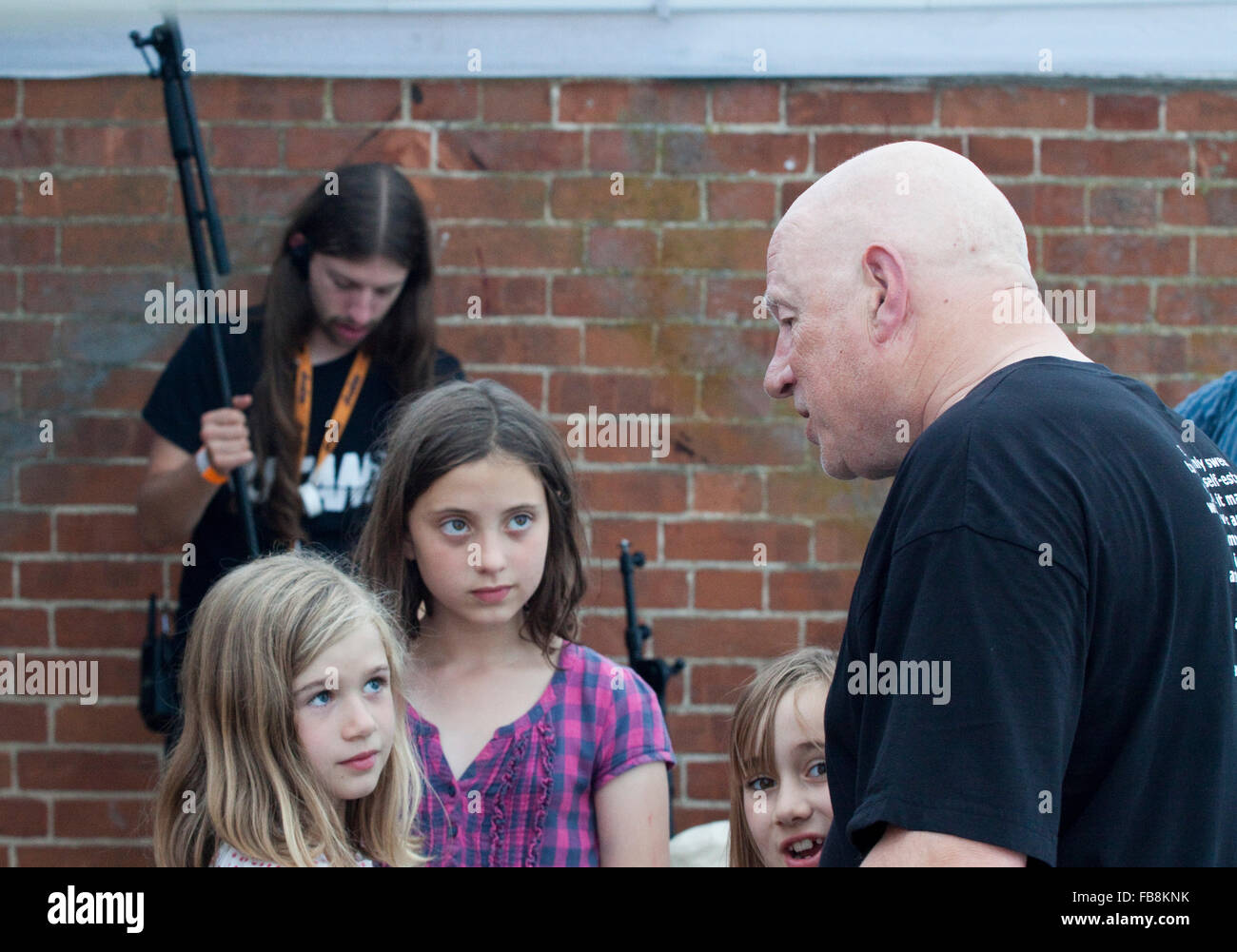 Neil Innes backstage nach der Show mit einigen jungen Mädchen, von denen einige zumindest sicherlich seine Enkelinnen sind Stockfoto