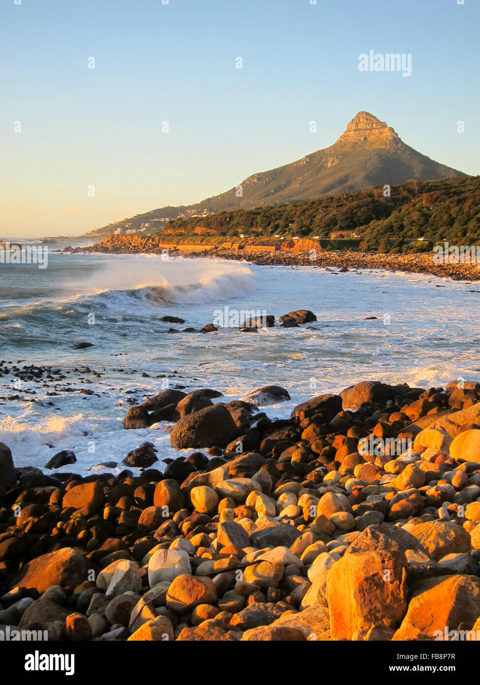 Küstenlinie an der Atlantikseite der Tafelberg in Südafrika. Des Löwen Kopf Berg und einer steinigen Bucht mit Wellen hereinkommen. Stockfoto