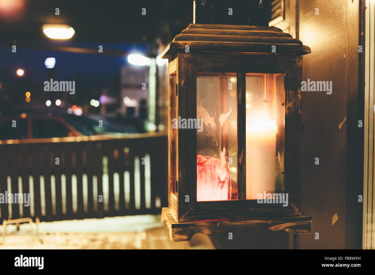 Brennende Kerze in einem Glaskasten auf der Straße vor einer Institution in der Nacht. Stockfoto