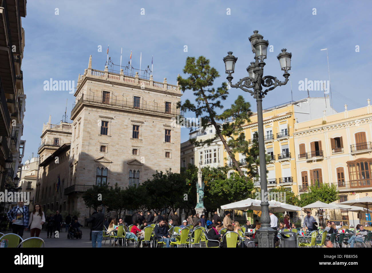 Touristen saßen in La Plaza De La Virgen, im Hintergrund El Palacio De La Generalidad, Valencia, Spanien. Stockfoto
