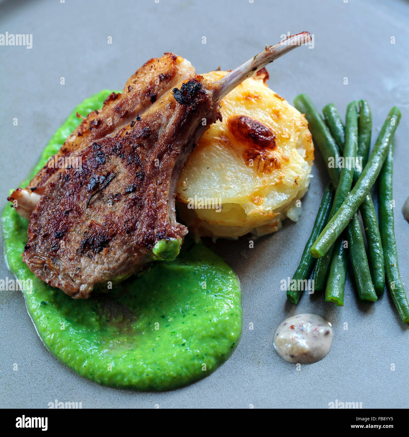 Lammkotelett mit Erbsen-Püree und Dauphinoise Kartoffeln Stockfoto