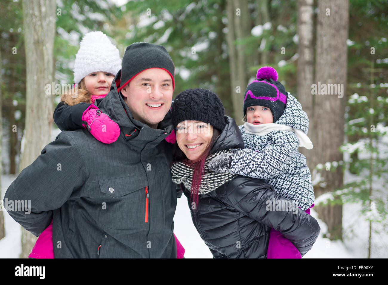 Glückliche Familie Spaziergänge und spielen mit Schnee im Winterwald Stockfoto