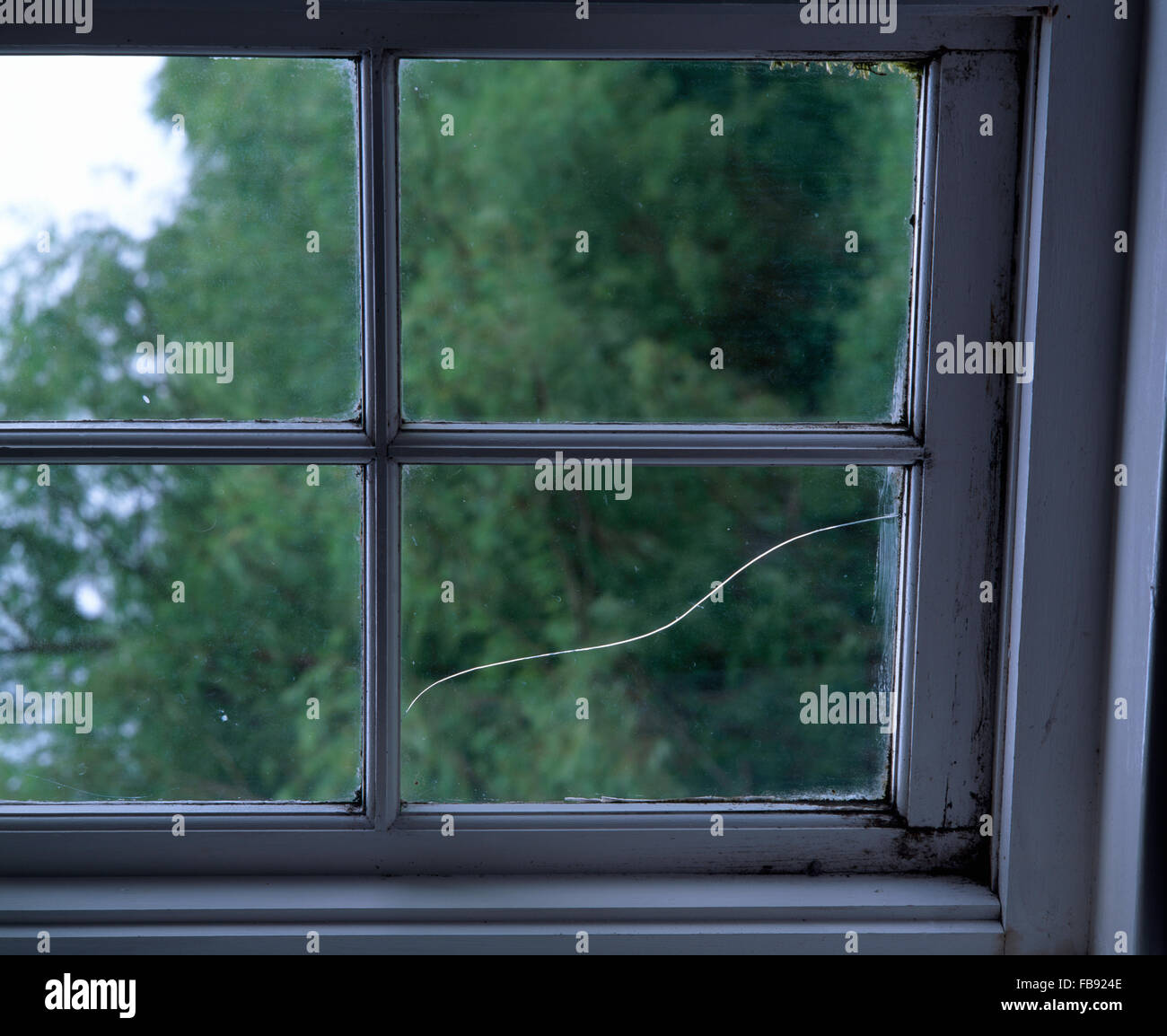 Nahaufnahme eines Fensters mit einer gebrochenen Glasscheibe Stockfoto