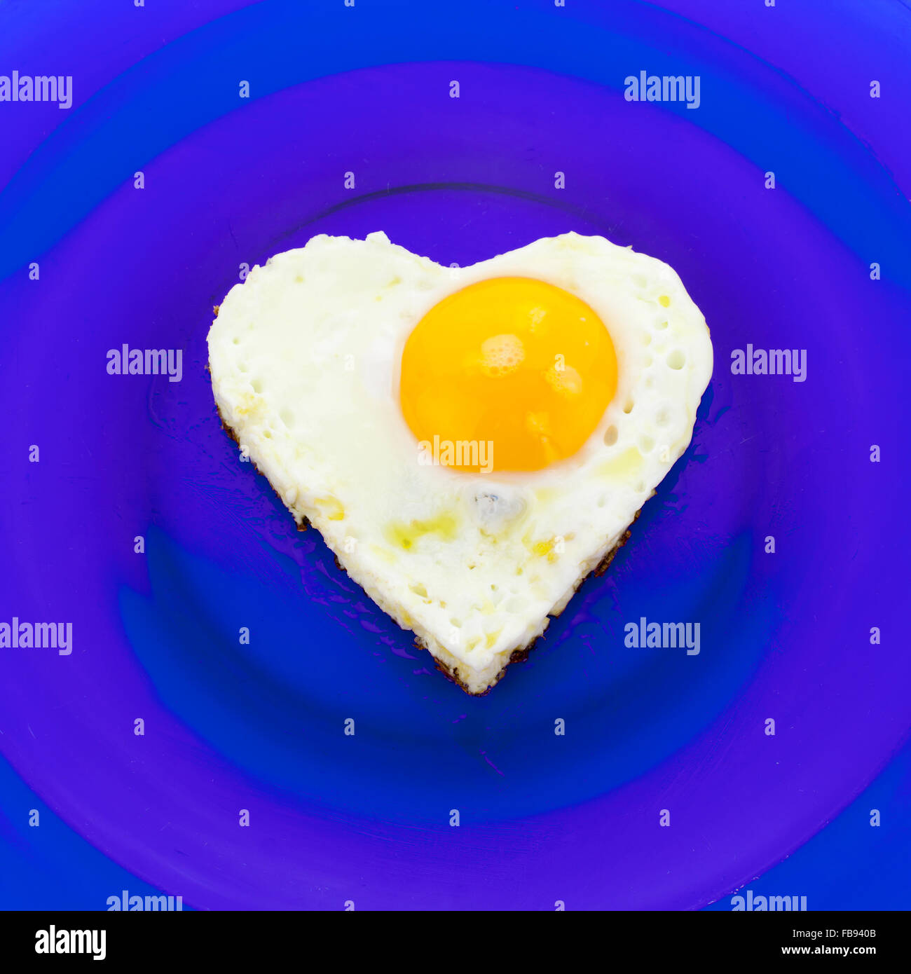 Ei auf blauen Teller in Herzform Stockfoto