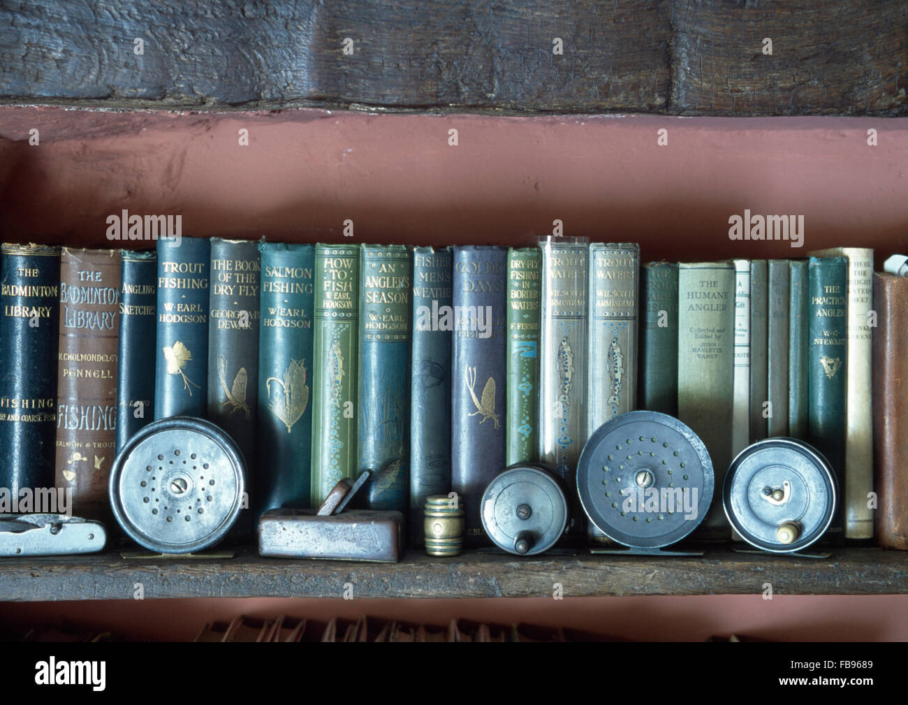 Sammlung von Hardcover Vintage Bücher über Angeln am Regal mit antiken Angelausrüstung Stockfoto