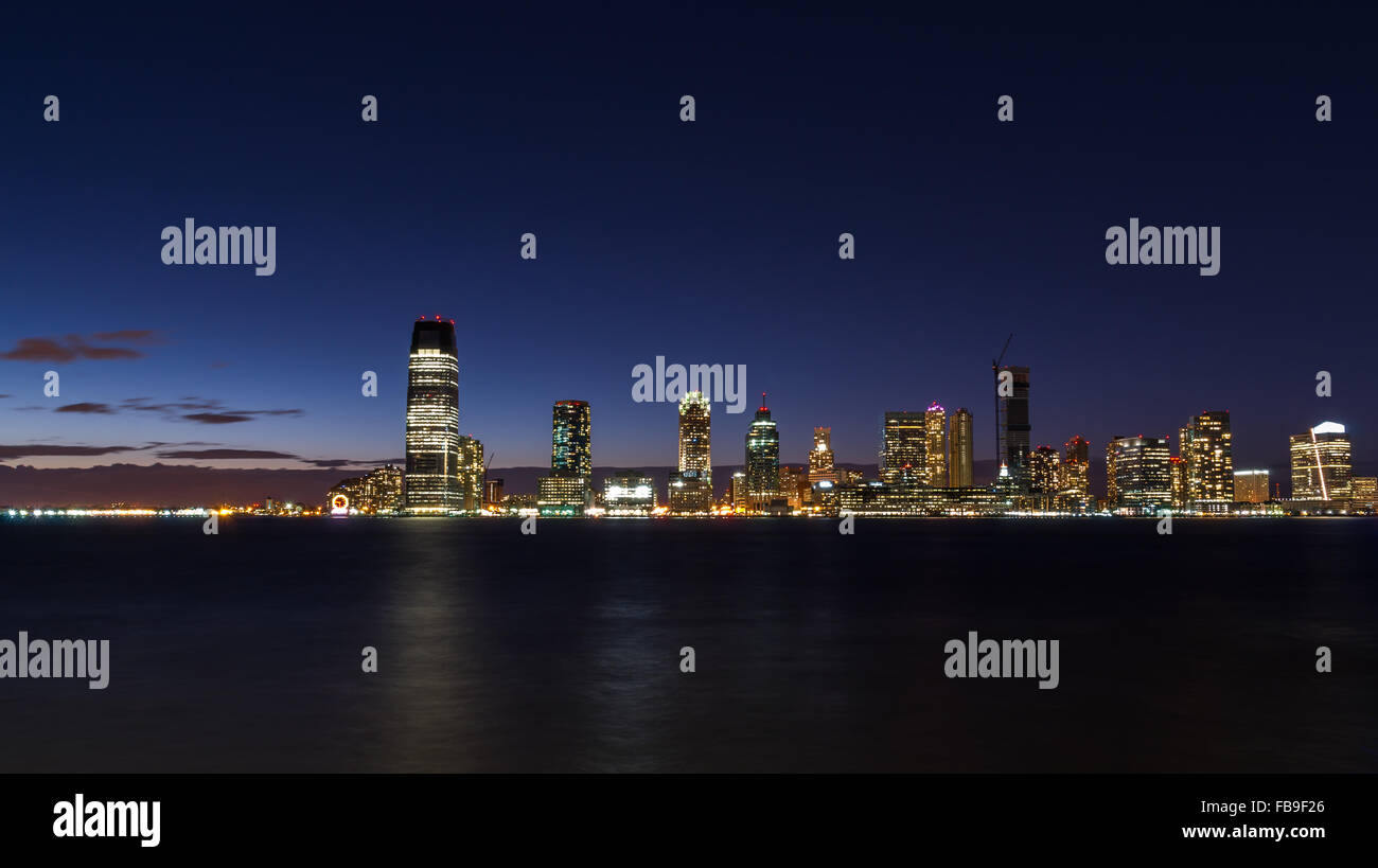 Die Paulus Hook, Jersey City-Skyline bei Nacht schoss aus über den Hudson River, mit Lichter der Stadt spiegelt sich im Wasser Stockfoto