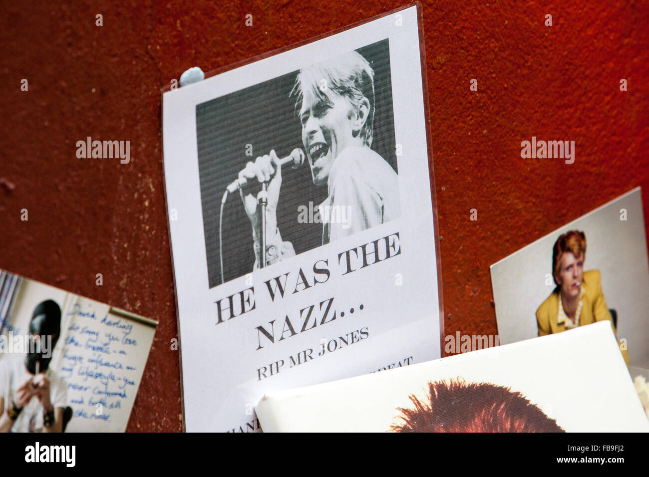 Ehrungen und Nachrichten von Fans liegen unter einem Wandgemälde der späten David Bowie Brixton u-Bahnstation, London, UK. © Martyn Wheatley/Alamy Live News Stockfoto