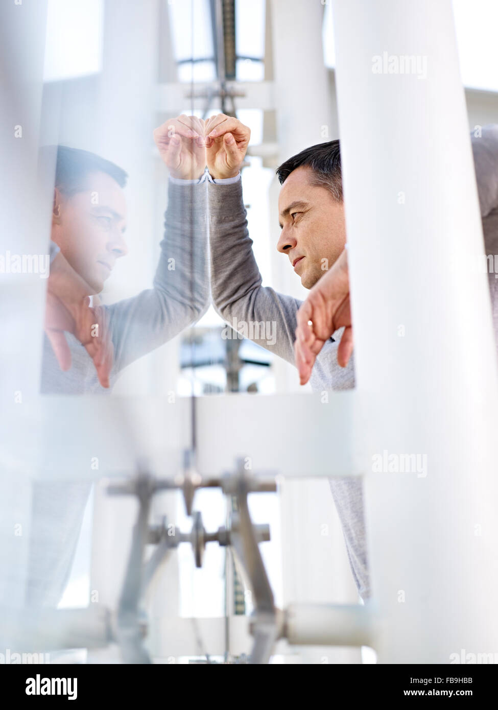 Kaukasische Geschäftsmann Blick aus Fenster und denken in modernes Bürogebäude. Stockfoto