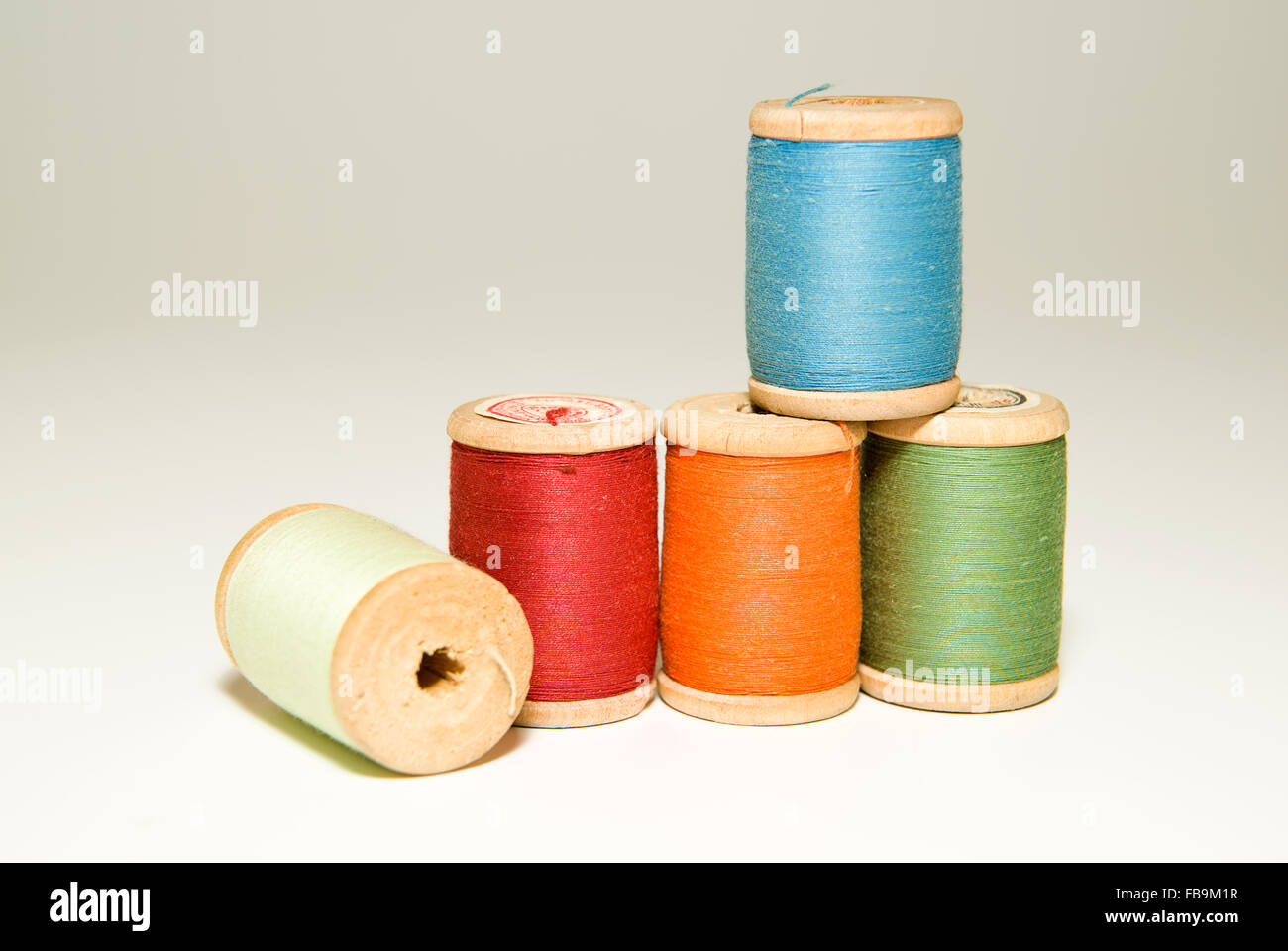 Mehrere Spulen des Threads in verschiedenen Farben auf über weiß Stockfoto