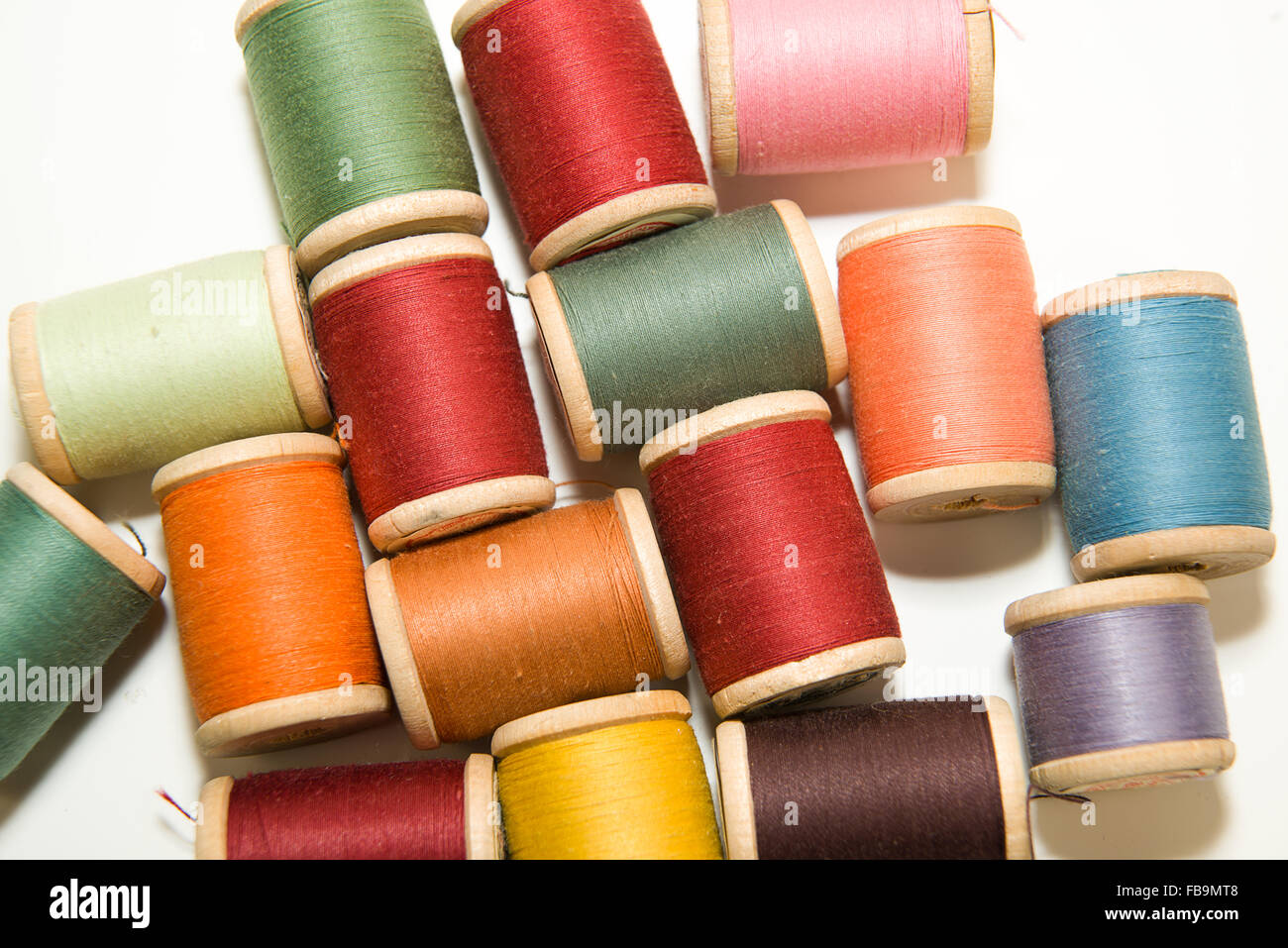 Viele Spulen des Threads in verschiedenen Farben auf über weiß Stockfoto