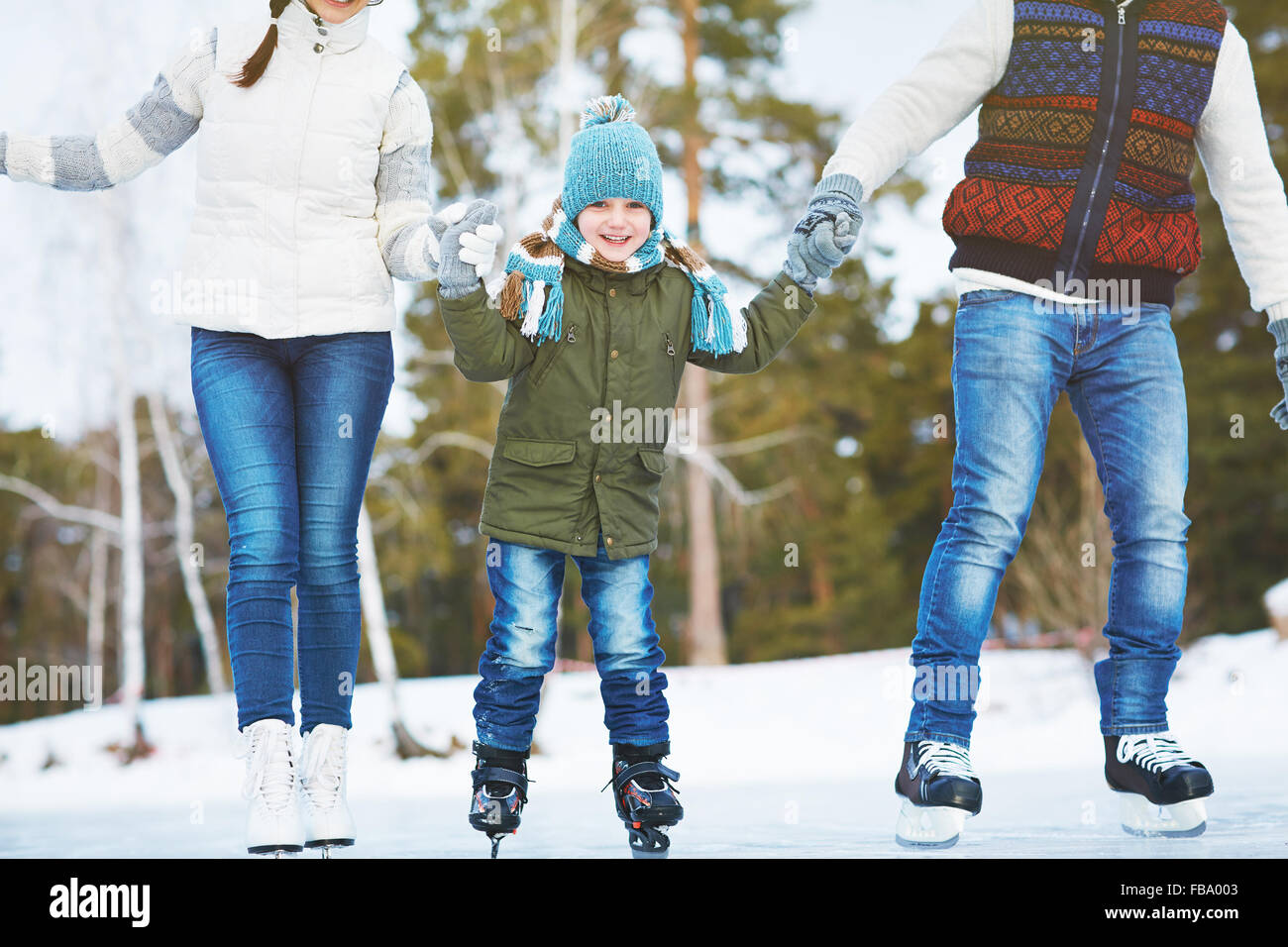 Glücklich kleiner Junge mit seinen Eltern zusammen Eislaufen Stockfoto
