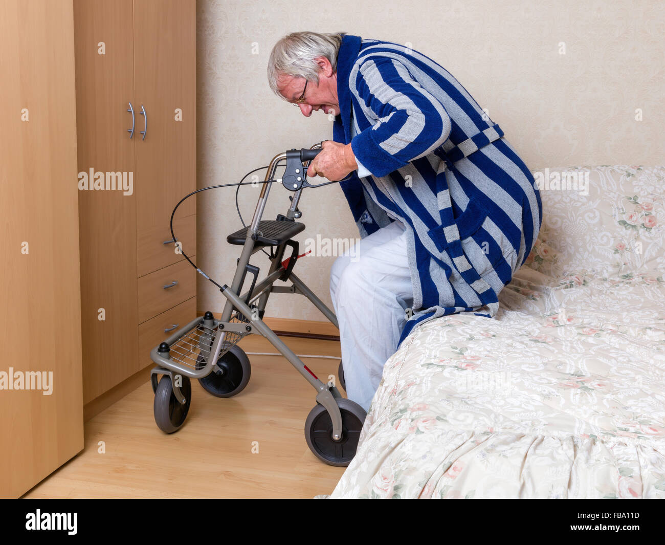 Ältere Großvater im Pflegeheim mit einem Rollator in seinem Pyjama Stockfoto