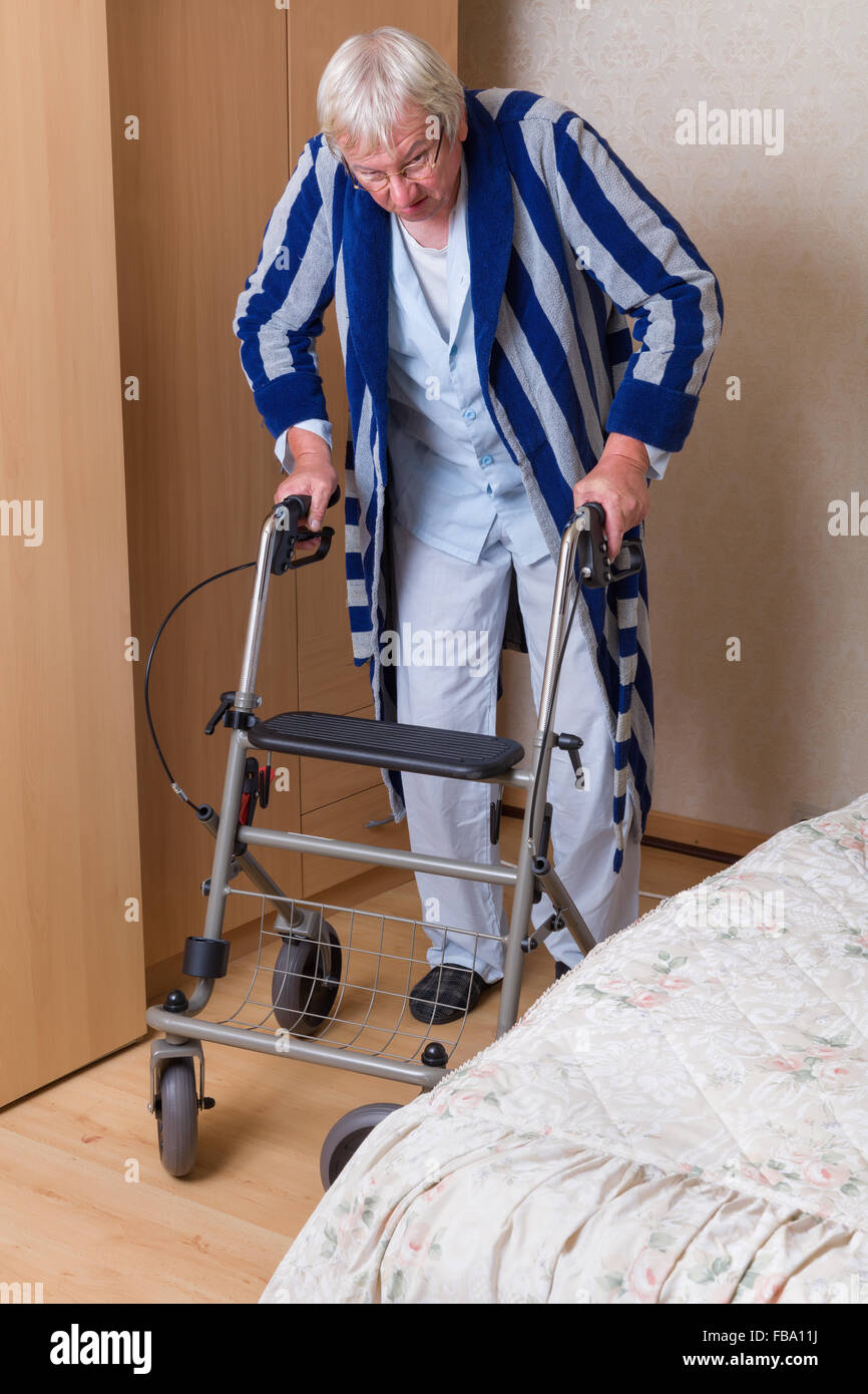 Ältere Großvater im Pflegeheim mit einem Rollator in seinem Pyjama Stockfoto