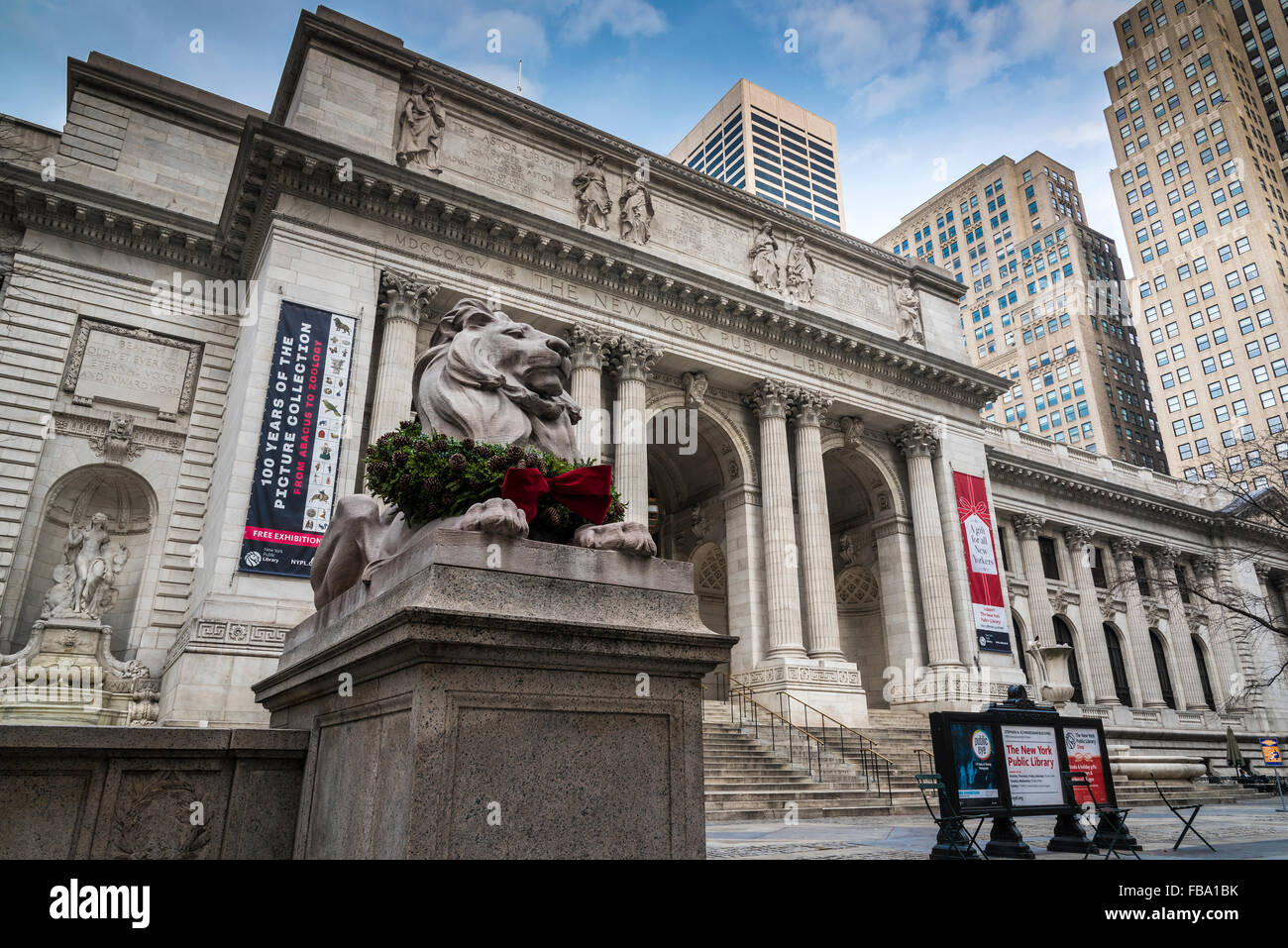 Marmor Löwe Skulptur geschmückt mit Weihnachtsschmuck, The New York Public Library, Manhattan, New York, USA Stockfoto
