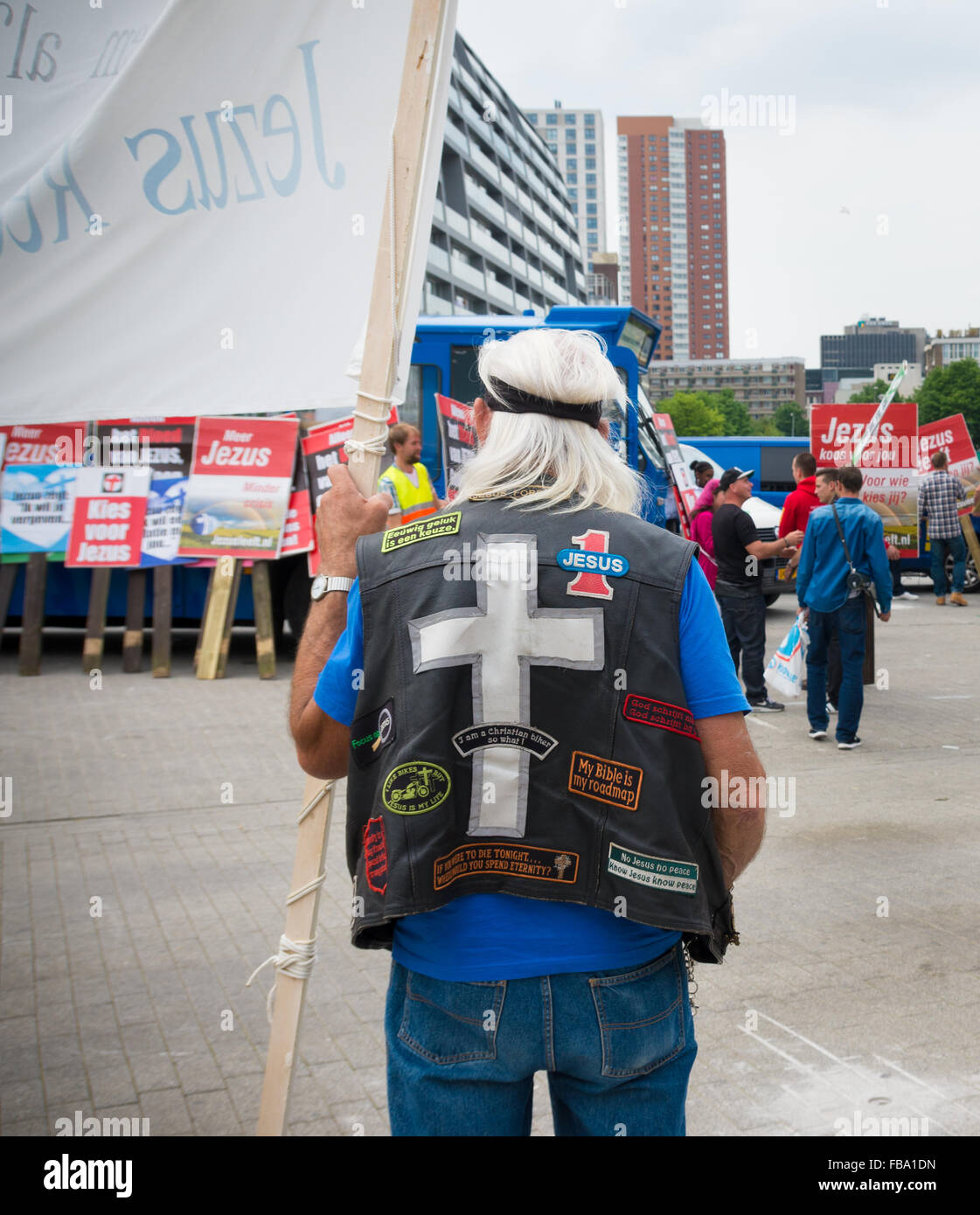 ROTTERDAM, Niederlande - 28. Juni 2015: Unbekannter Mann mit Jacke voll mit Jesus Symbole hält einen Banner während einer religiösen demo Stockfoto