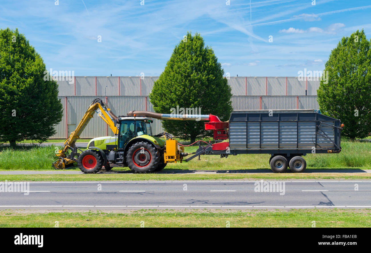 Traktor Rasenmähen entlang einer Straße Stockfoto