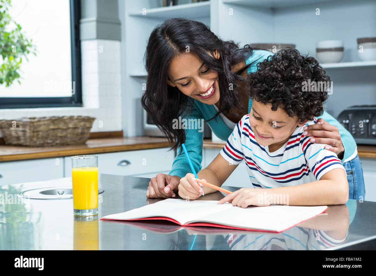 Gute Mutter ihren Sohn Hausaufgaben zu helfen Stockfoto
