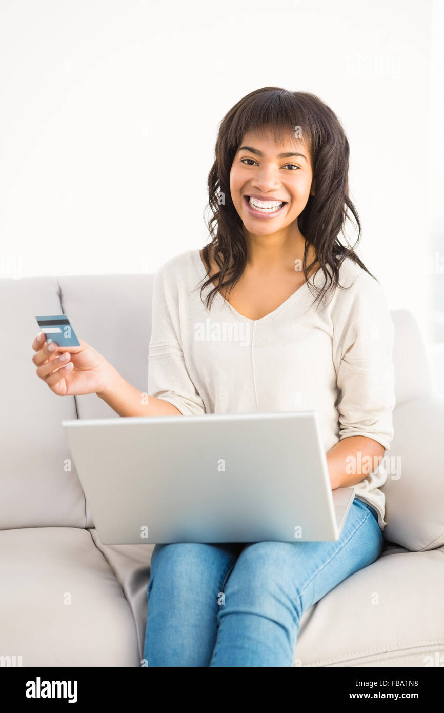 Lächelnde lässige Frau Dinge mit ihrem Laptop kaufen Stockfoto