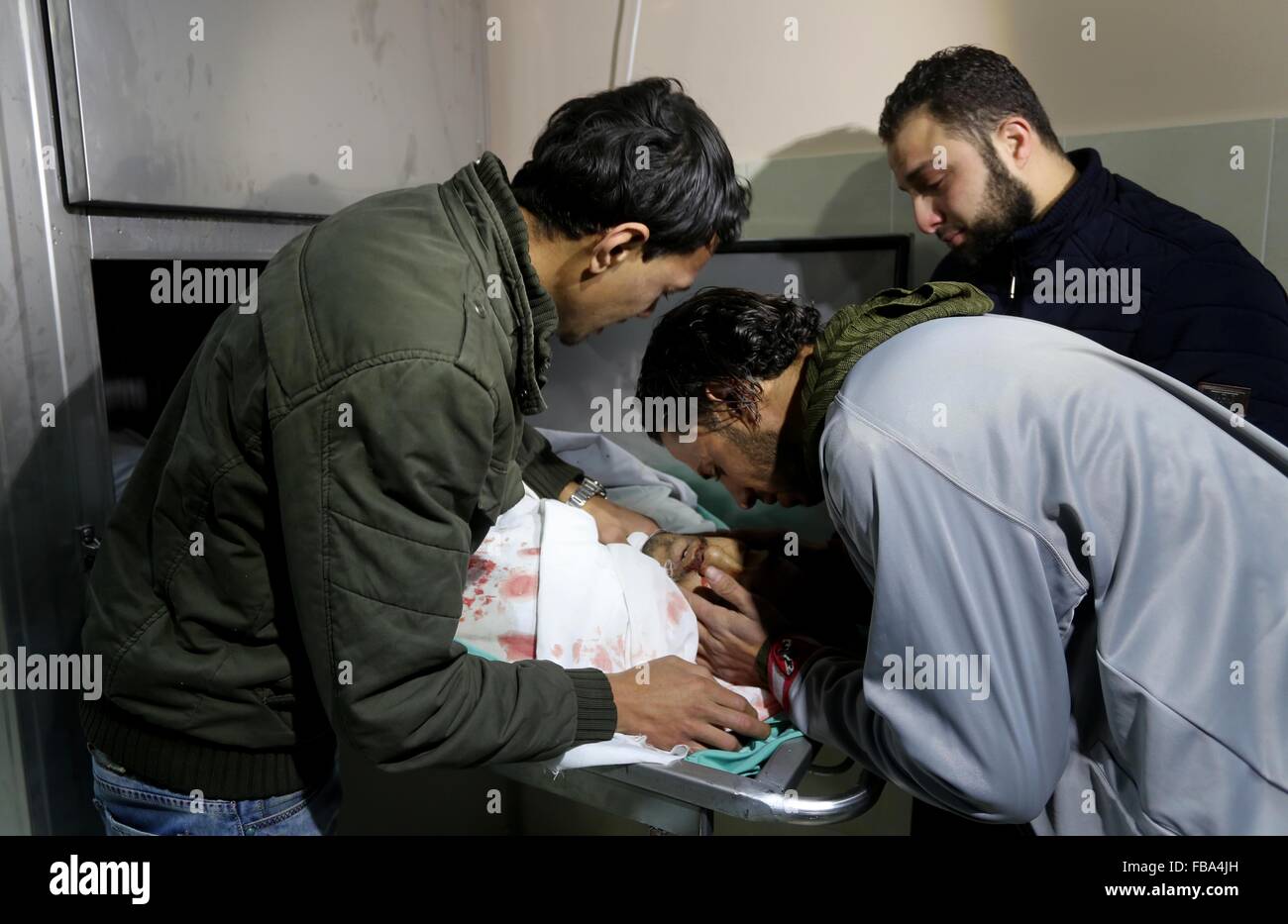 Gaza-Stadt, Gazastreifen, Palästinensische Gebiete. 13. Januar 2016. Angehörigen der palästinensischen Moussa Zuaiter, trauern über seinen Körper an einem Leichenschauhaus im Krankenhaus im nördlichen Gazastreifen 13. Januar 2016. Die israelische Kampfflugzeuge überfiel eine Gruppe der Palästinenser im Gaza-Streifen am Mittwoch, die das Militär sagte geplant, an der Grenze zu Israel eine Bombe detonieren, und eine palästinensische militante Fraktion sagte einer seiner Männer getötet wurde Credit: Mohammed Asad/APA Bilder/ZUMA Draht/Alamy Live News Stockfoto