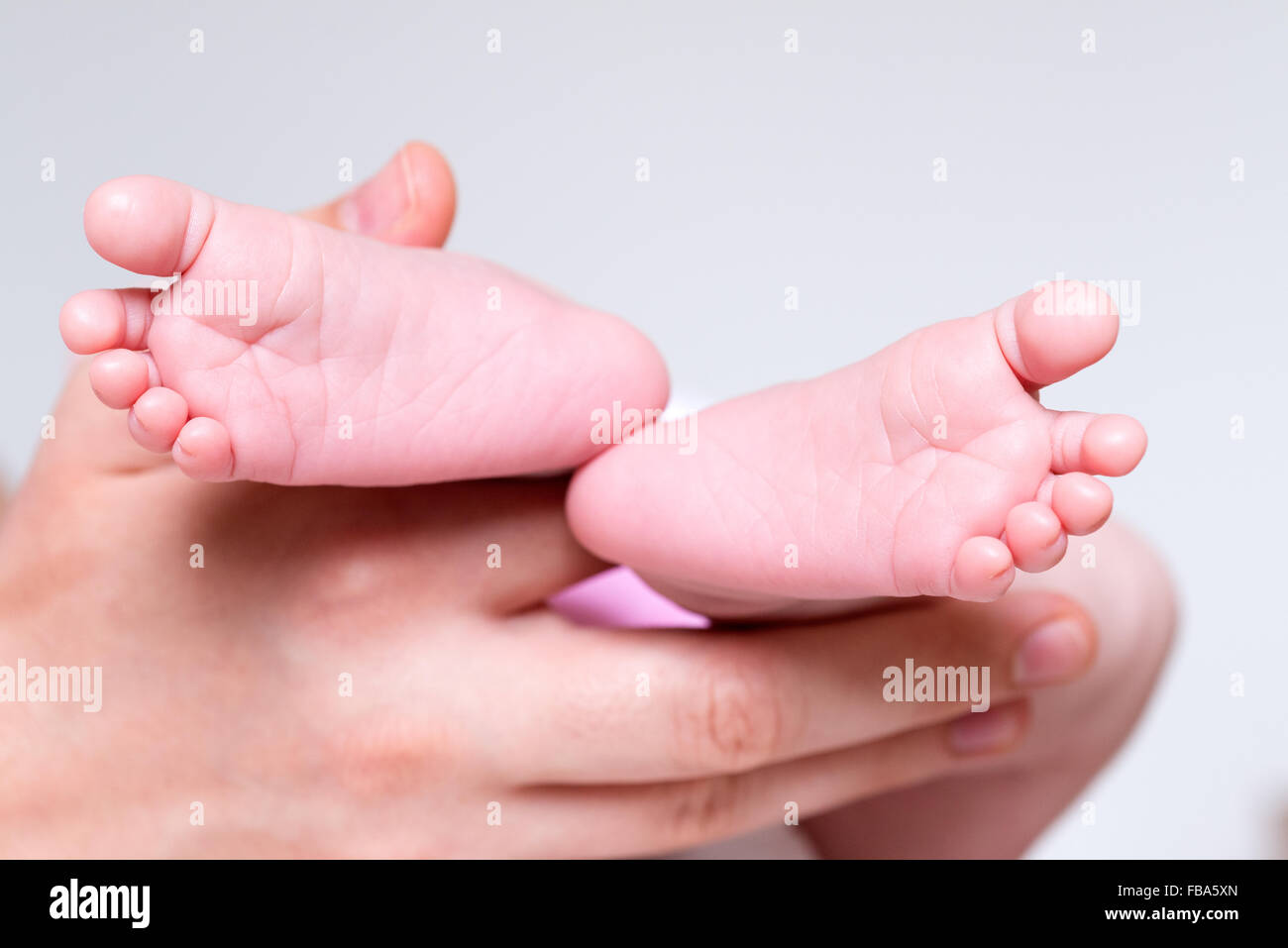 Nahaufnahme von Hand mit neugeborenen Babys Füße Stockfoto